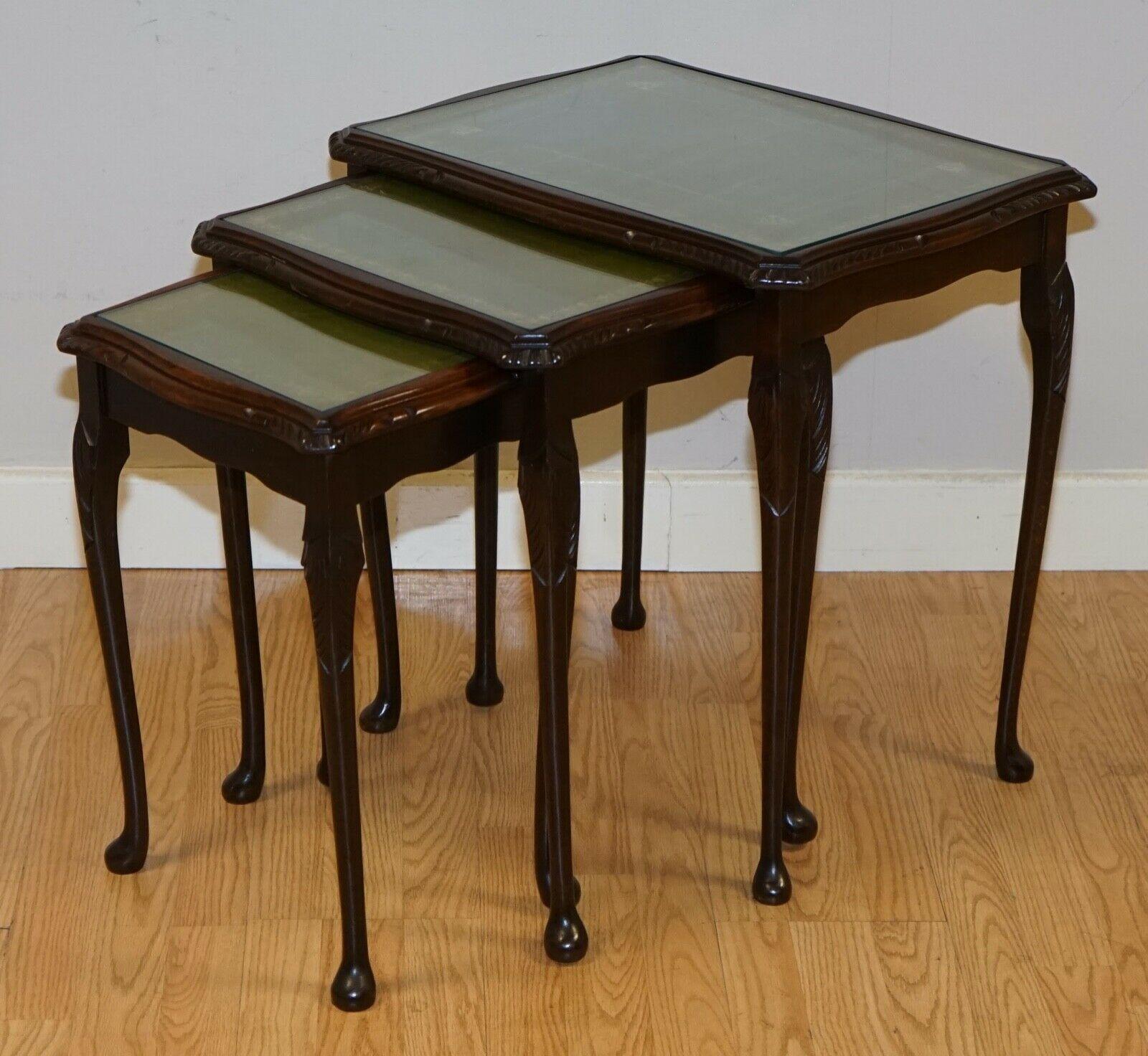 We are delighted to offer this vintage nest of tables with green leather top, they include glass tops which is very helpful to keep the leather undamaged. 

They have some marks here and there but nothing significant, and this just adds character