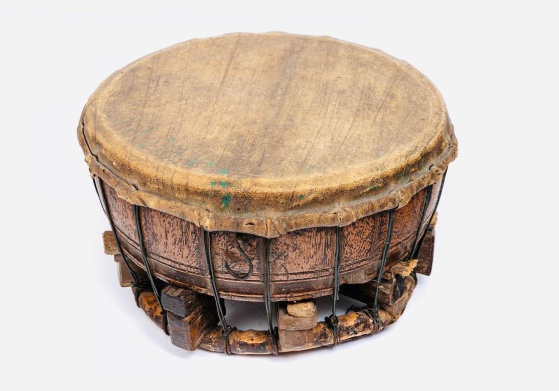 An authentic Tribal drum in all original condition. The Hardwood body of the Drum features fine Graining and has substantial weight. The very tight construction has a solid wraparound Rattan Base and several wood peg inserts to achieve tension. The