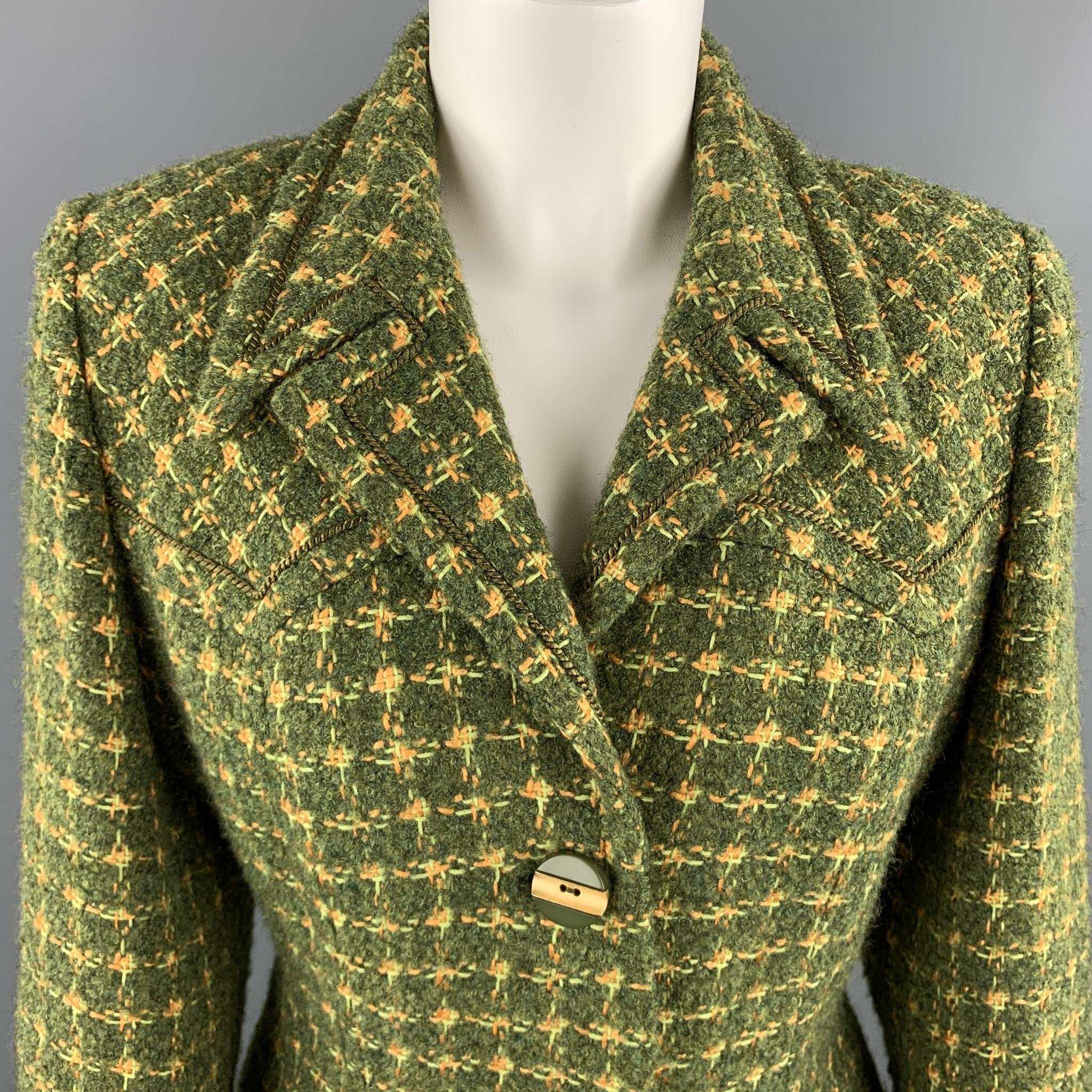 Vintage HARDY AMIES skirt suit comes in green and gold tweed and includes a single breasted blazer with a downward peak lapel, rope piping, acrylic green and metallic gold statement buttons and matching pencil skirt. Made in UK.

Excellent Pre-Owned