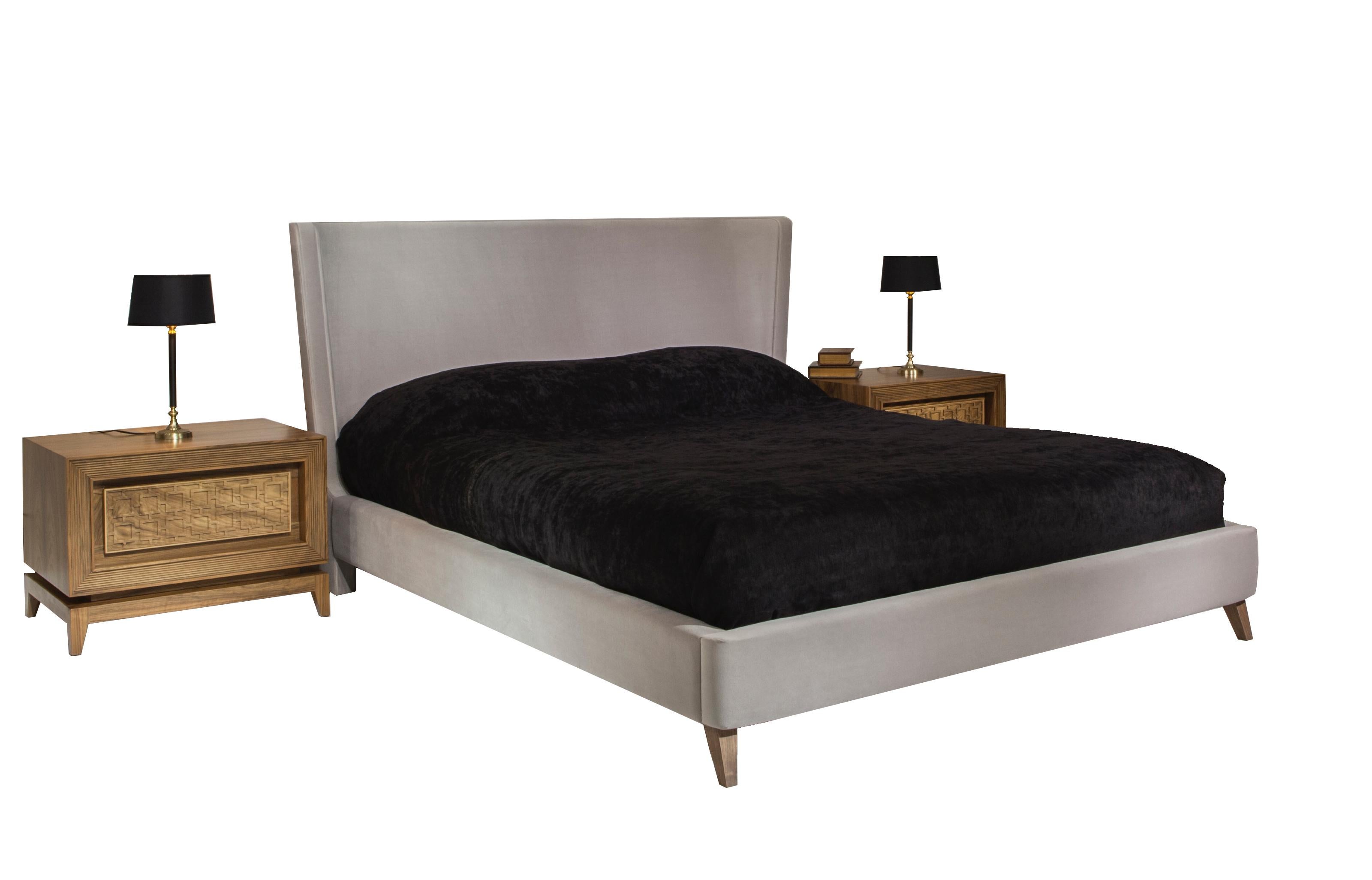 Das Bett Harem hat ein gepolstertes Untergestell auf eleganten, spitz zulaufenden Massivholzbeinen. Das zierliche, invertierte Kopfteil mit sanft geschwungenen Kanten bringt einen raffinierten Luxus ins Schlafzimmer.