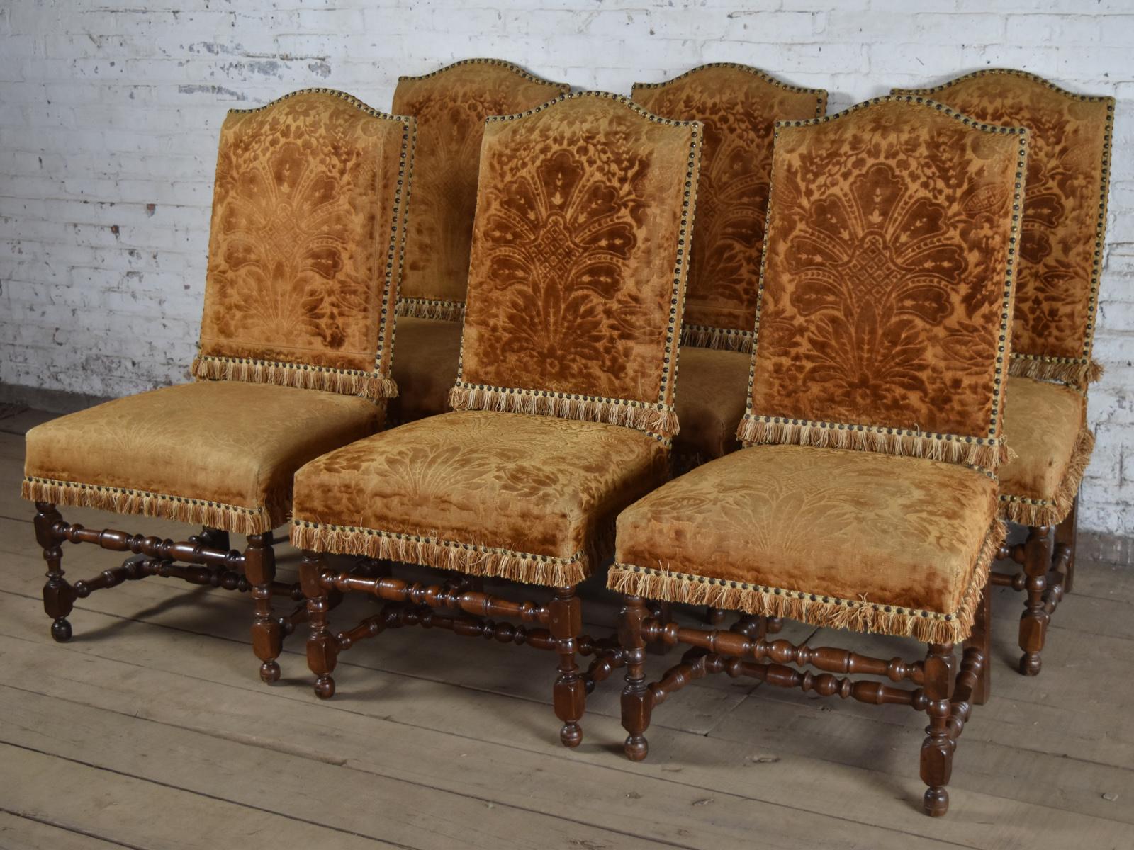A Harlequin Set of 12 French Louis XIII 17th Century Walnut and upholstered Side Chairs of beautiful quality, generous Proportions and solid pegged construction. The twelve chairs having rounded tops to the backs, turned front legs connected by  a