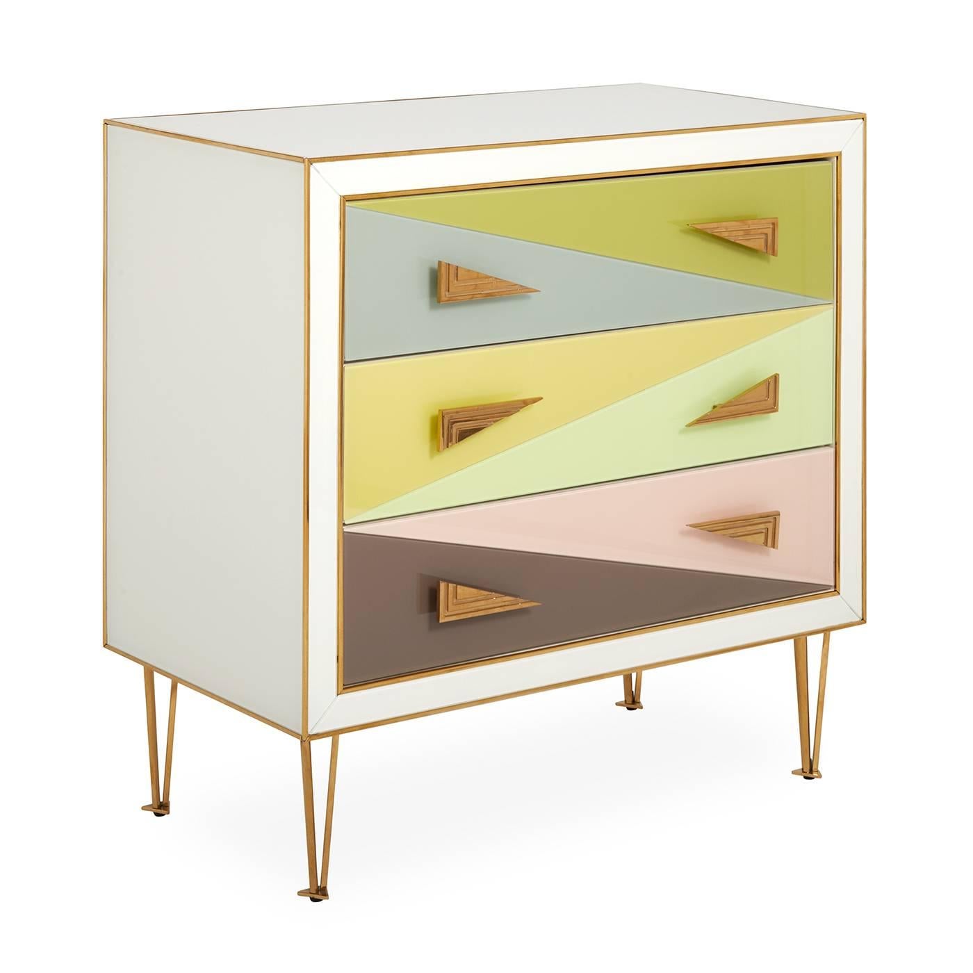 Avant Wow. A little Italian Modern, a lot of irresistible color. Our Harlequin Three-Drawer Chest features back-painted glass panes in angular forms in muted, sunrise-inspired hues. The ivory case is tipped with brass edging, adorned with