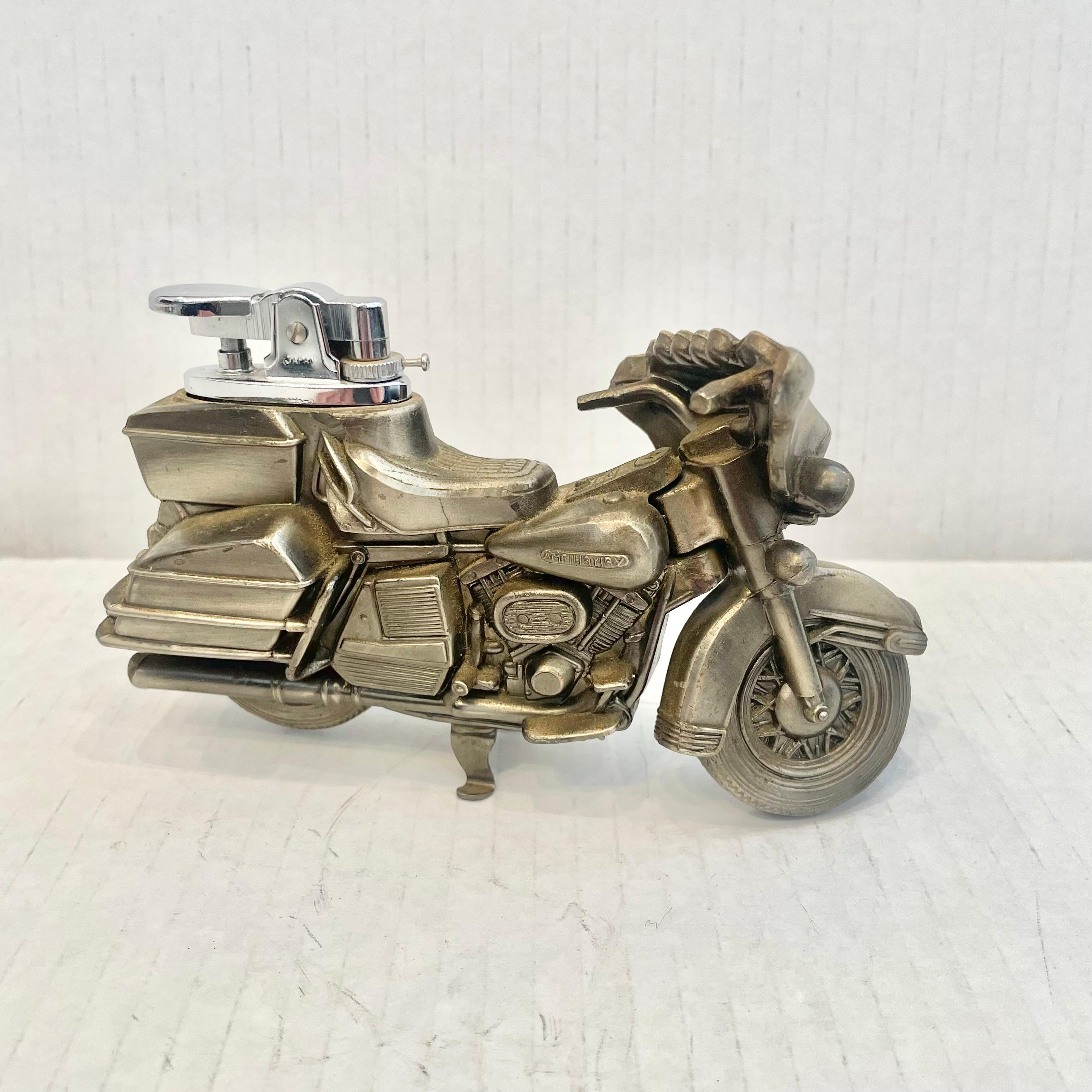 Great vintage table lighter in the shape of a AMF Harley Davidson motorcycle. In 1969, the AMF corporation (American Machine and Foundry) took over production of Harley-Davidson motorcycles. Made completely of metal with a hollow body. Great dark