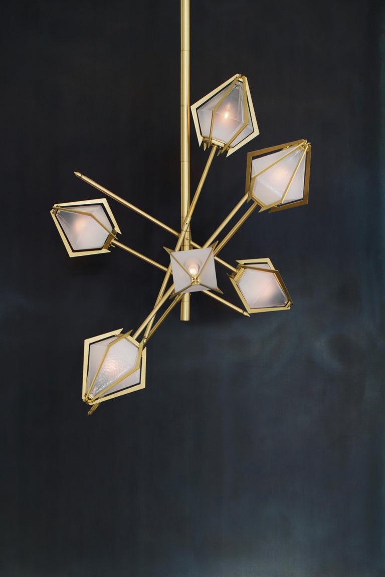 The Harlow small chandelier is an elegant sculptural light fixture inspired by jewelry design featuring a mold-blown glass gem in a chic metallic setting to create an asymmetrical starburst of light. Harlow is available in various color ways, and