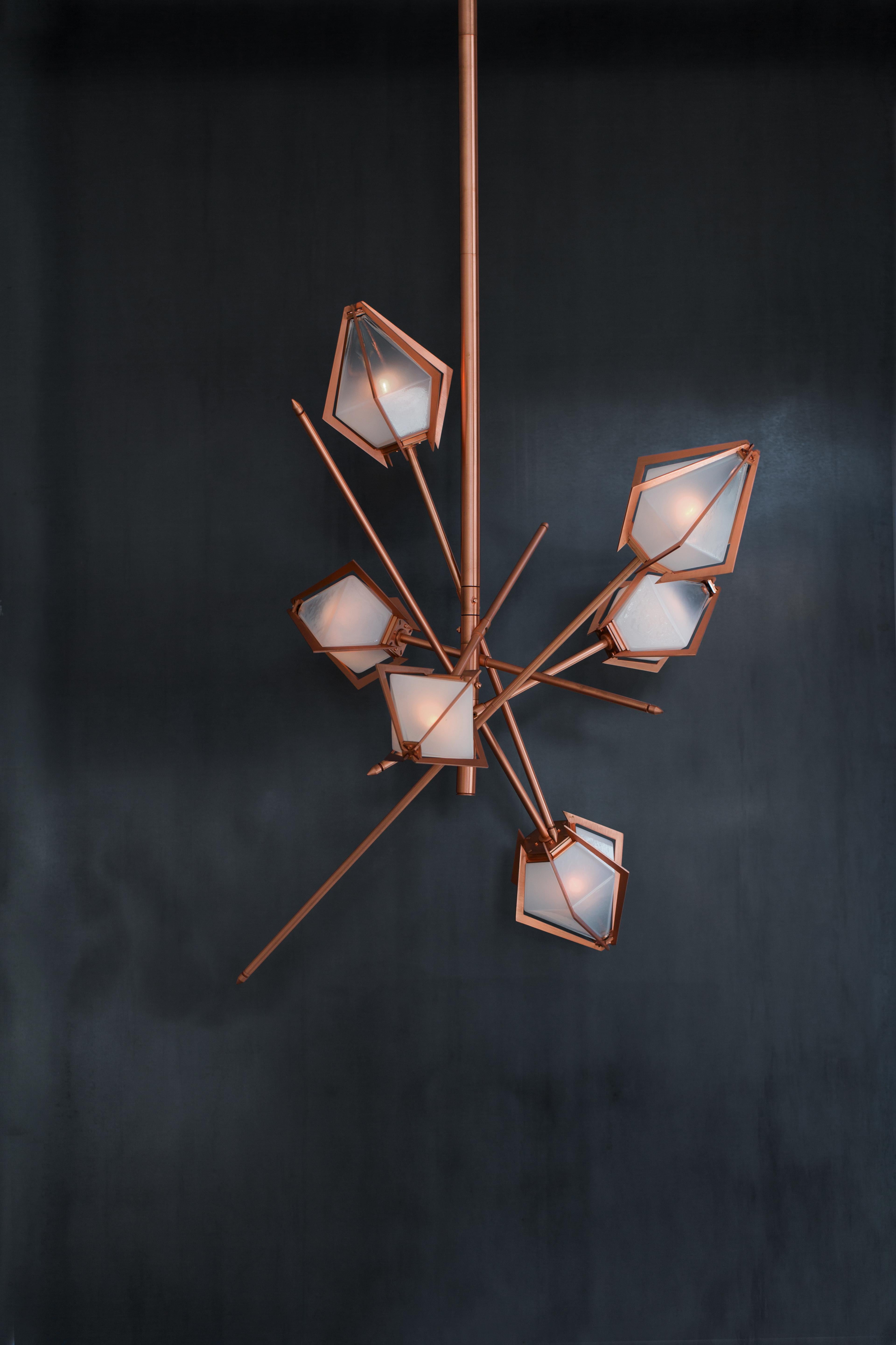 The Harlow small chandelier is an elegant sculptural light fixture inspired by jewelry design featuring a mold-blown glass gem in a chic metallic setting to create an asymmetrical starburst of light. Harlow is available in various color ways, and