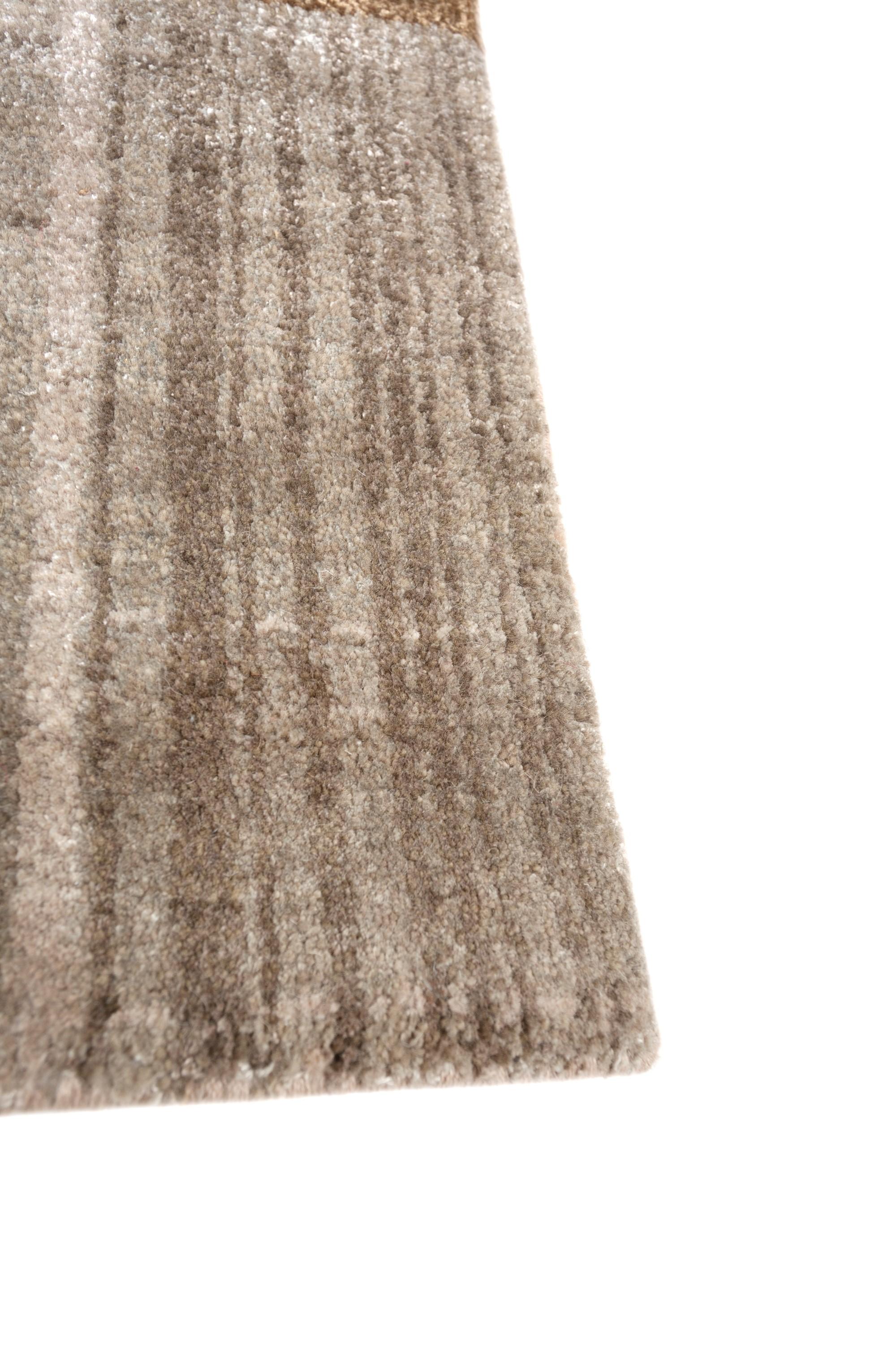 Wir stellen Ihnen diesen handgeknüpften Teppich vor, der in sorgfältiger Handarbeit im ländlichen Indien hergestellt wird. Mit einem dunklen elfenbeinfarbenen Grundton und einer Bordüre, die an reife Brombeeren erinnert, zeigt der Teppich