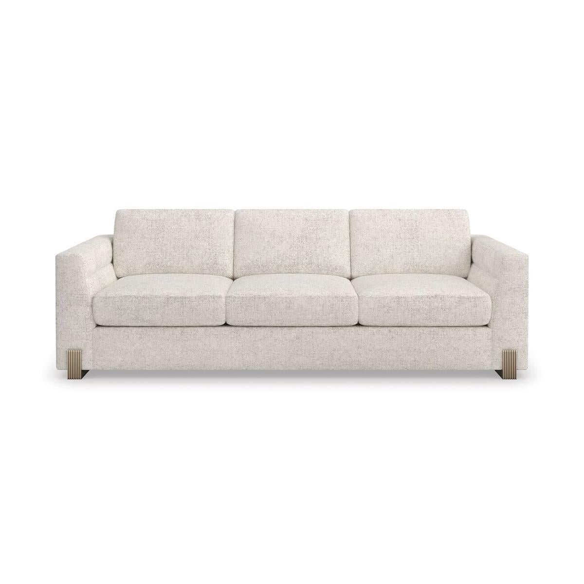 A refined mix of texture and material, the sofa is soft-lined yet sophisticated in an oatmeal melange woven fabric with subtle rust threading. Channel-tufted arms with a slightly angled taper comfortably enclose its loose seat back cushions, propped