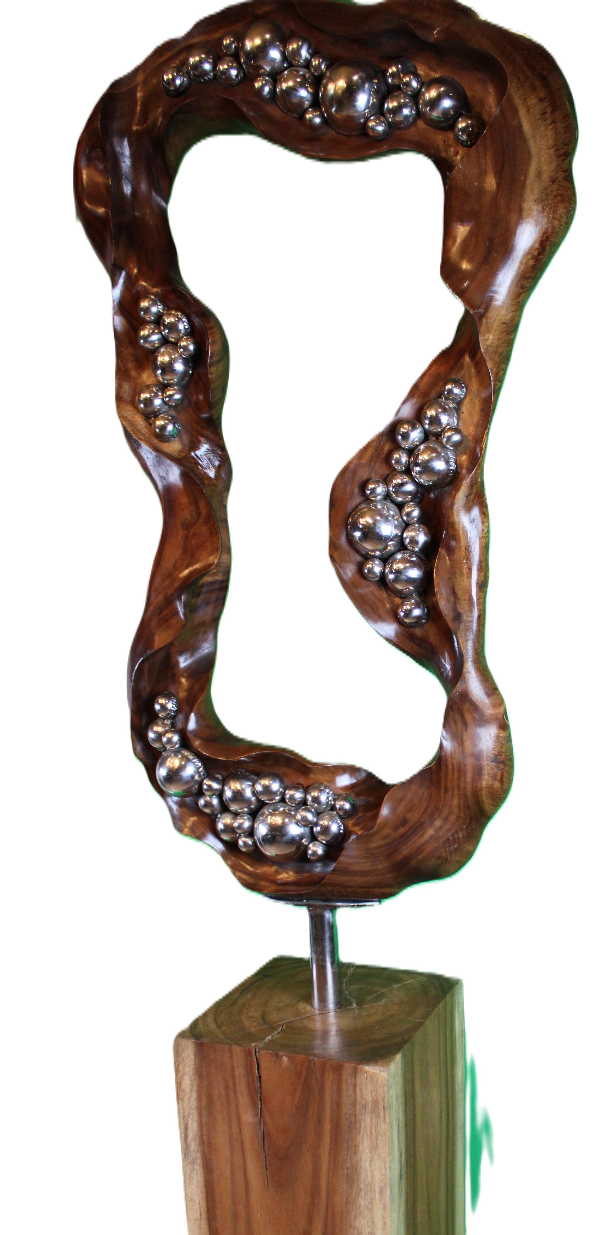 Questa affascinante scultura astratta balinese, posta su una base di legno lucido, trascende la semplice forma. Le sue curve sinuose evocano il flusso e riflusso della vita, una danza tra radici terrene e aspirazioni celestiali.

Fluidità in Wood: