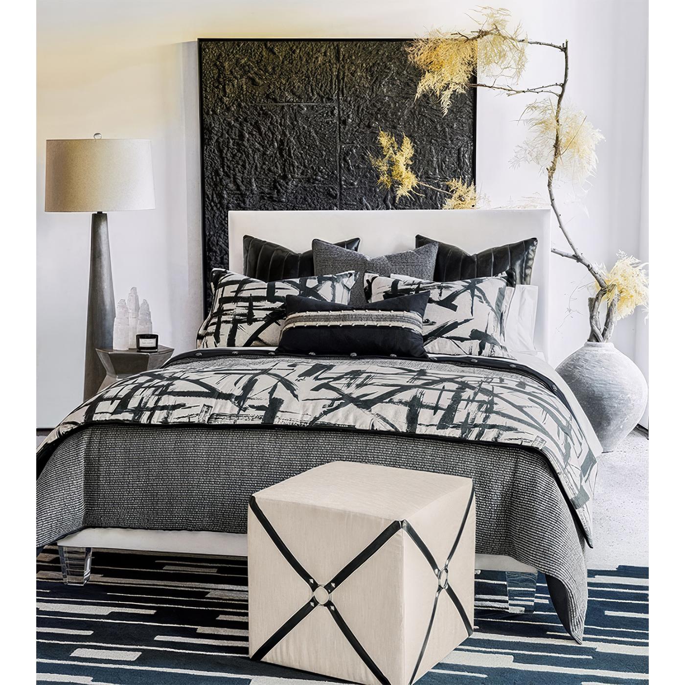 Upholstered in a luxurious ivory fabric, this cube ottoman exudes sophistication, while its vegan leather harness accents and pyramid nailhead details introduce an edgy yet refined aesthetic. The symmetrical, structured design is perfect for
