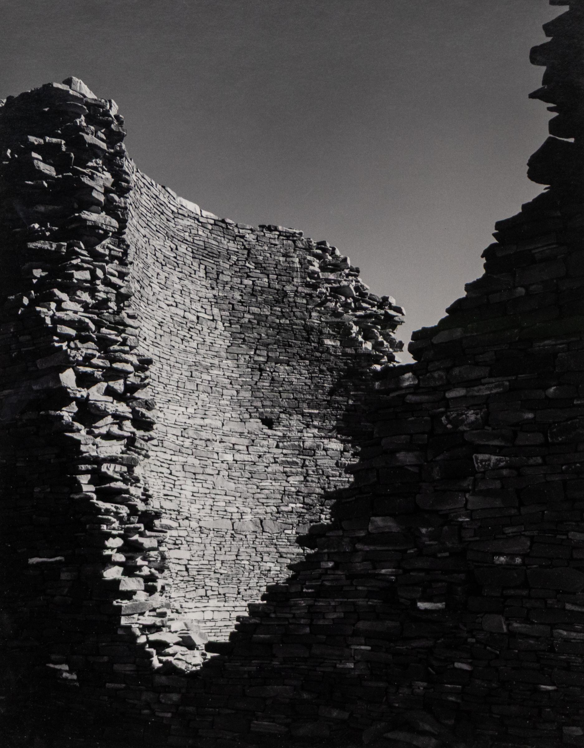 This original black and white photograph by Harold E. Malde captures a striking and historically significant view of Kin Klizhin, a Chacoan great house constructed in the 1080s in what is now the American Southwest. Rendered with clarity and tonal