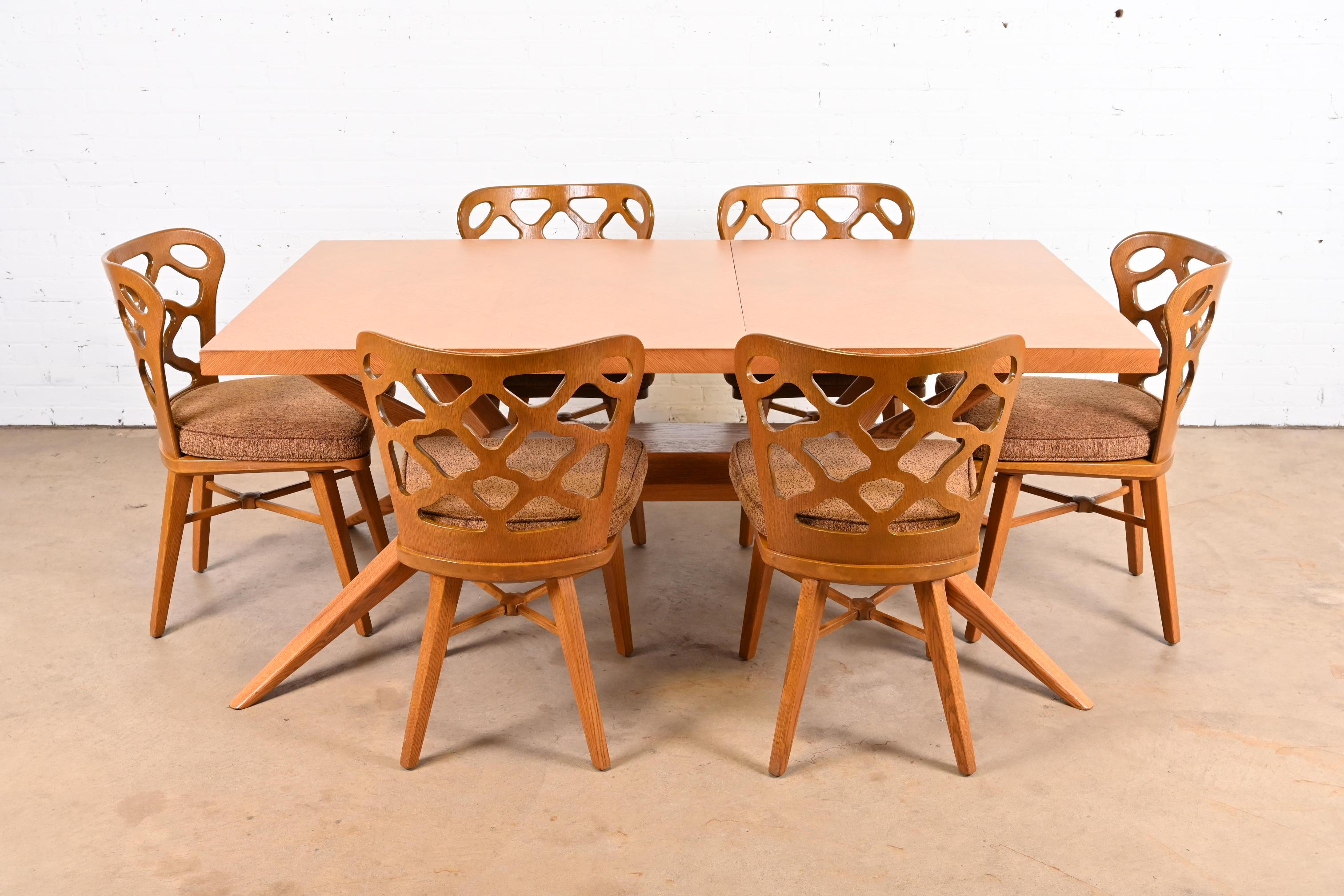 A rare and exceptional Mid-Century Modern dining set

By Harold Schwartz for Romweber

USA, 1950s

Table is sculpted oak with parquetry top, splayed spider legs, and unique felt-lined cutlery drawers on each end. Chairs are sculpted oak, with