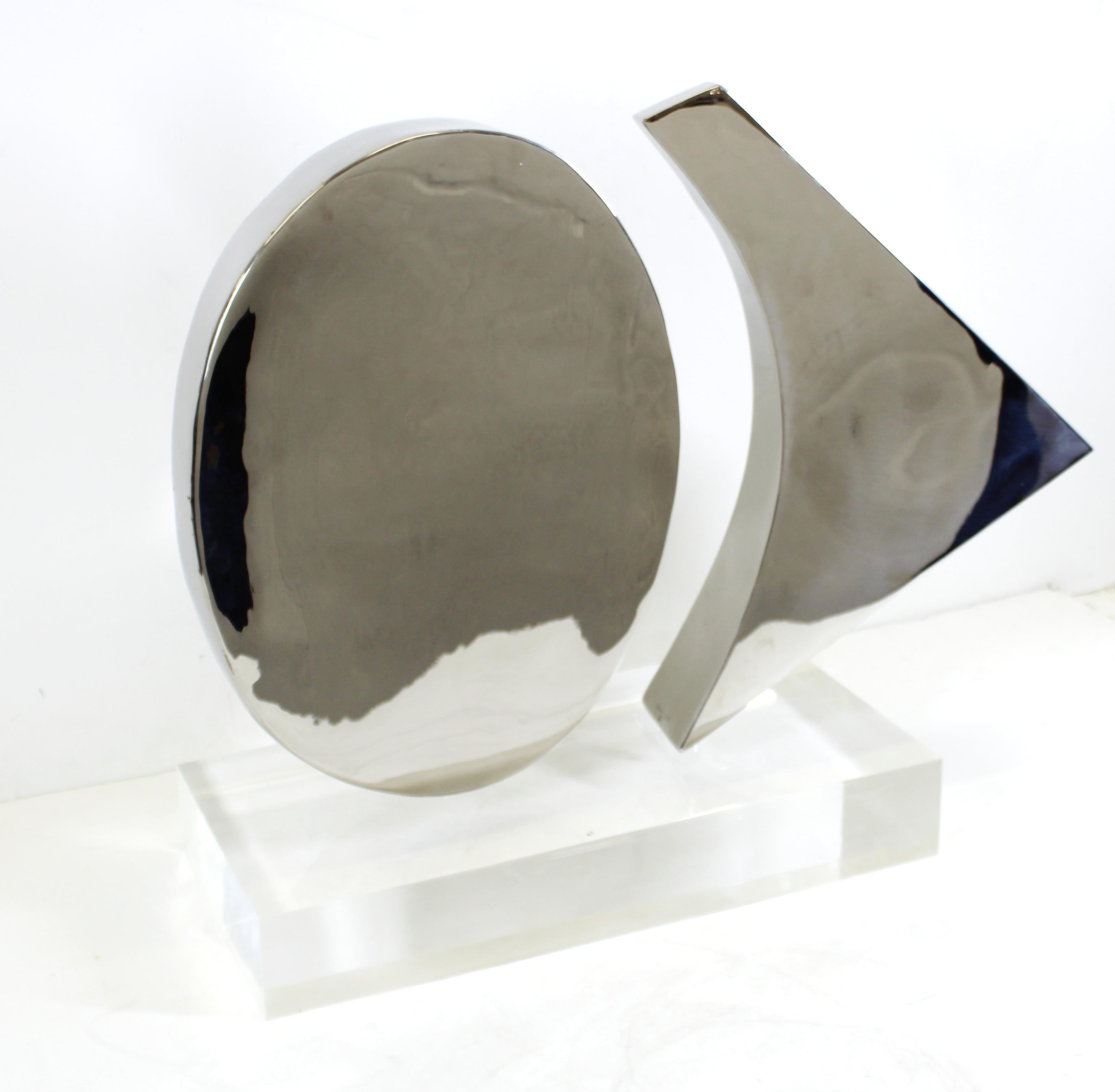 Modern abstract chromed metal sculpture of two rotating shapes mounted on a heavy acrylic base, created by New York artist Harold Sclar (NY 1930-2003), signed and dated 1977. In great vintage condition with age-appropriate wear and use.