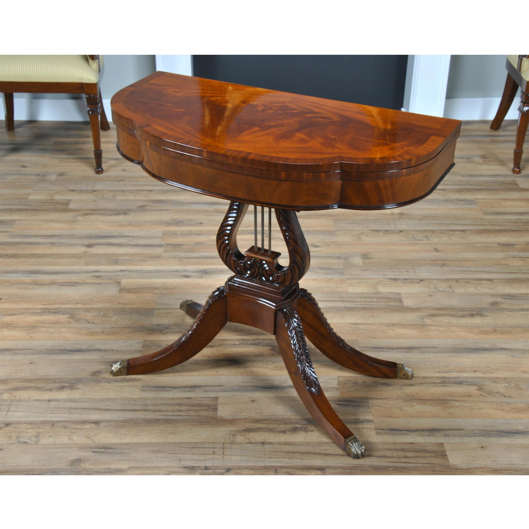An antique reproduction Lyre or Harp Game Table inspired by a Duncan Phyfe design this high quality item is both decorative and versatile. The table can be used with the top in the closed position as a hallway or entrance piece, it can also be