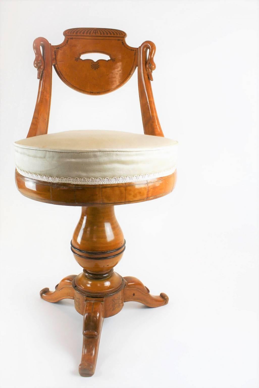 Exquise et rare chaise pivotante française Charles X - Restauration Harpist en bois d'érable massif avec filets d'amarante.
Motif col de cygne dans le dos, motif feuille de palmier composé de feuilles stylisées et d'arabesques florales, autour du