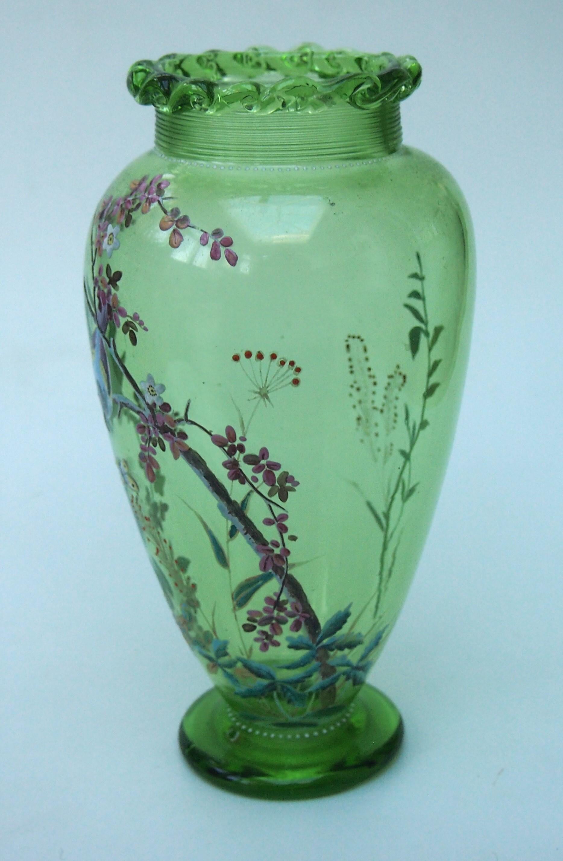 Good example of a footed enamelled green glass vase by Harrach c1890. The vase is decorated with a piped glass top and fine banding just below -It is finely polychrome enamelled with a cute scene of two birds (possibly blue tits)  sitting in