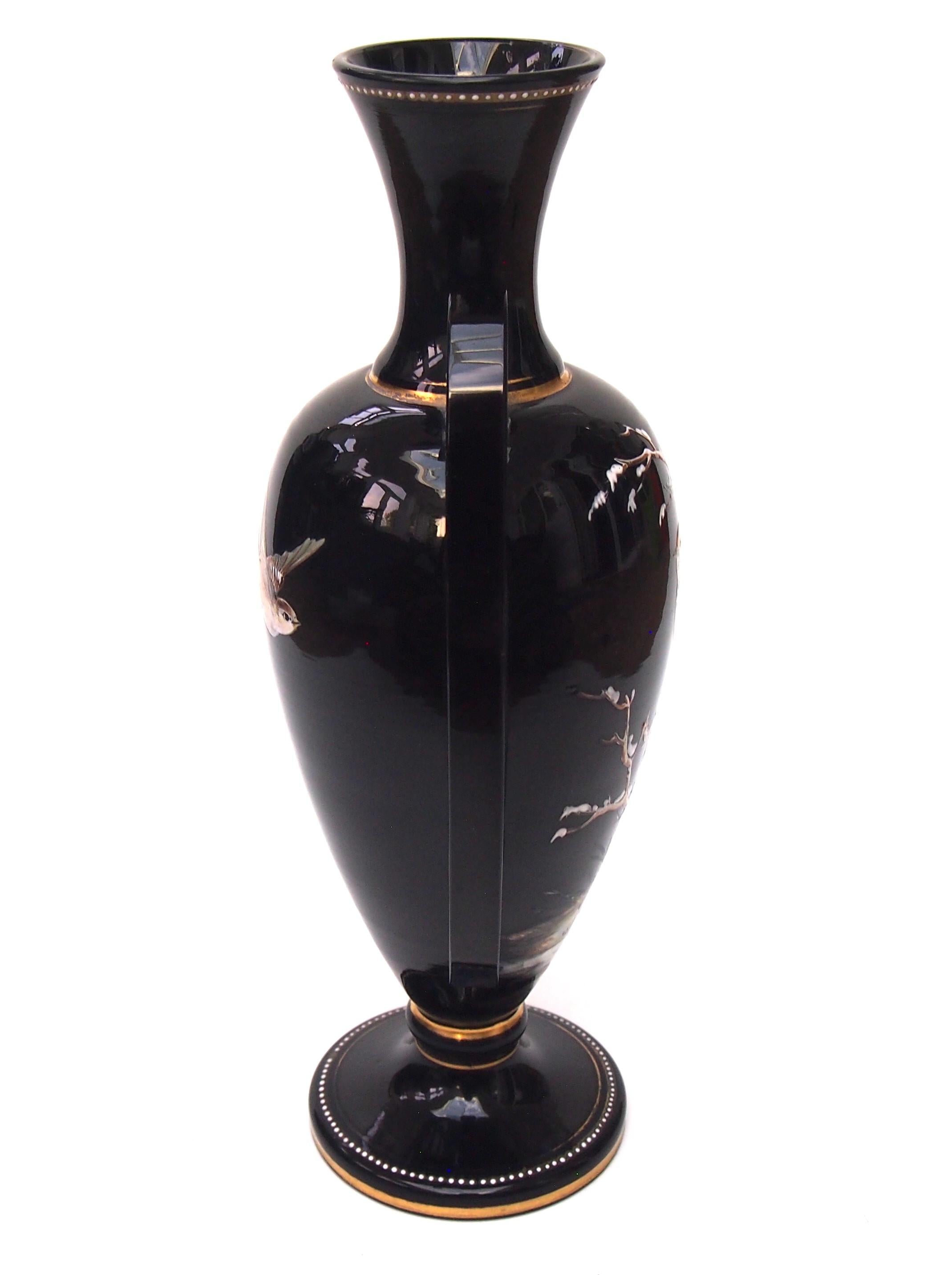 Fabulous Harrach vase in the classic Victorian style with their signature winged applications. The Vase is enamelled and gilded with a cute bird on snowy branches to the front and a bird in flight to the rear. The long vase 'wings' are applied and