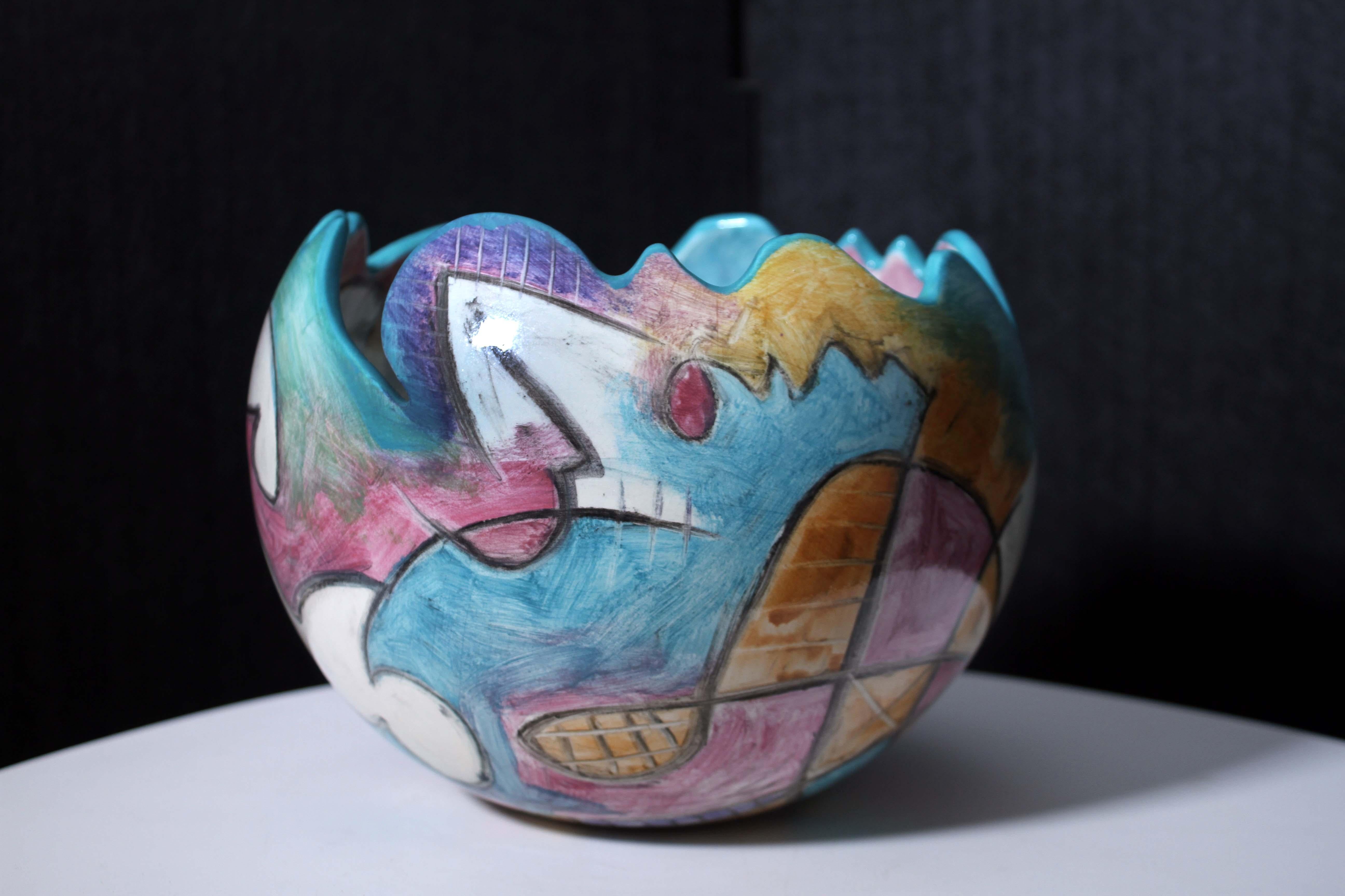 A delightful vintage abstract cubist style terracotta pottery bowl by Harris-Cies Studio. Signed on the bottom with a 1996 date. Made from earthenware clay with airbrushed color and a clear glaze. Stunning geometric patterns in pastel colors makes a