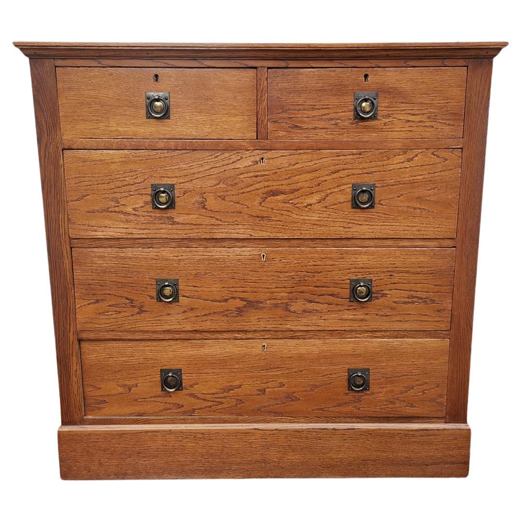 Harris Lebus an Arts & Crafts Oak Chest of Drawers with Brass Ring Pull Handles