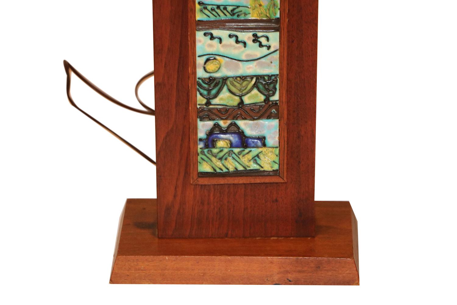 Un'affascinante e unica lampada da tavolo rettangolare in legno di metà secolo, disegnata da Harris Strong, intorno agli anni Sessanta. Presenta piastrelle in ceramica intarsiata multicolore nei toni del blu e del verde. Veramente un'opera d'arte