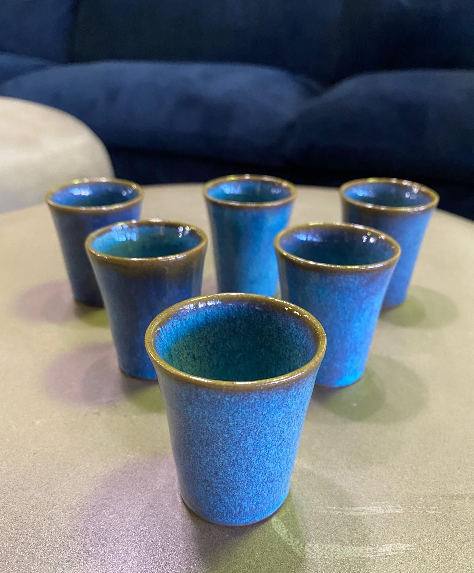Ein exquisit geformter und tiefblau glasierter Satz von sechs Sake-/Likörbechern aus Keramik des renommierten amerikanischen Westküsten-Keramikers Harrison McIntosh, der für seine Keramik im Mid-Century Modern Design berühmt war.

Mcintoshs Werke