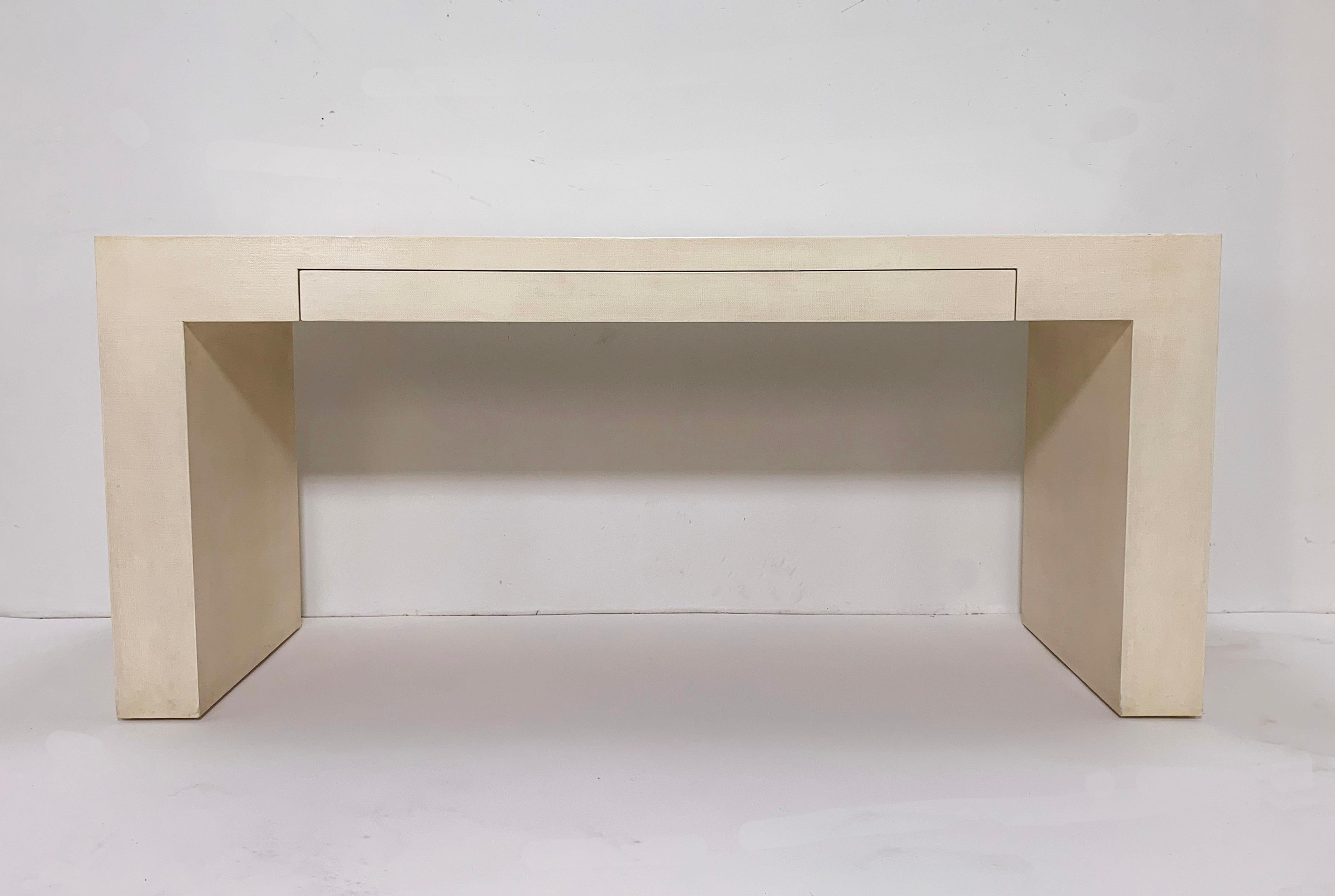 A postmodern lacquered linen console desk, circa 1980s, from the LA atelier of Flint Harrison & Jay Van Horn. A sleek architectural block form styling with elongated central pencil drawer from the duo who were highly influential in the furniture