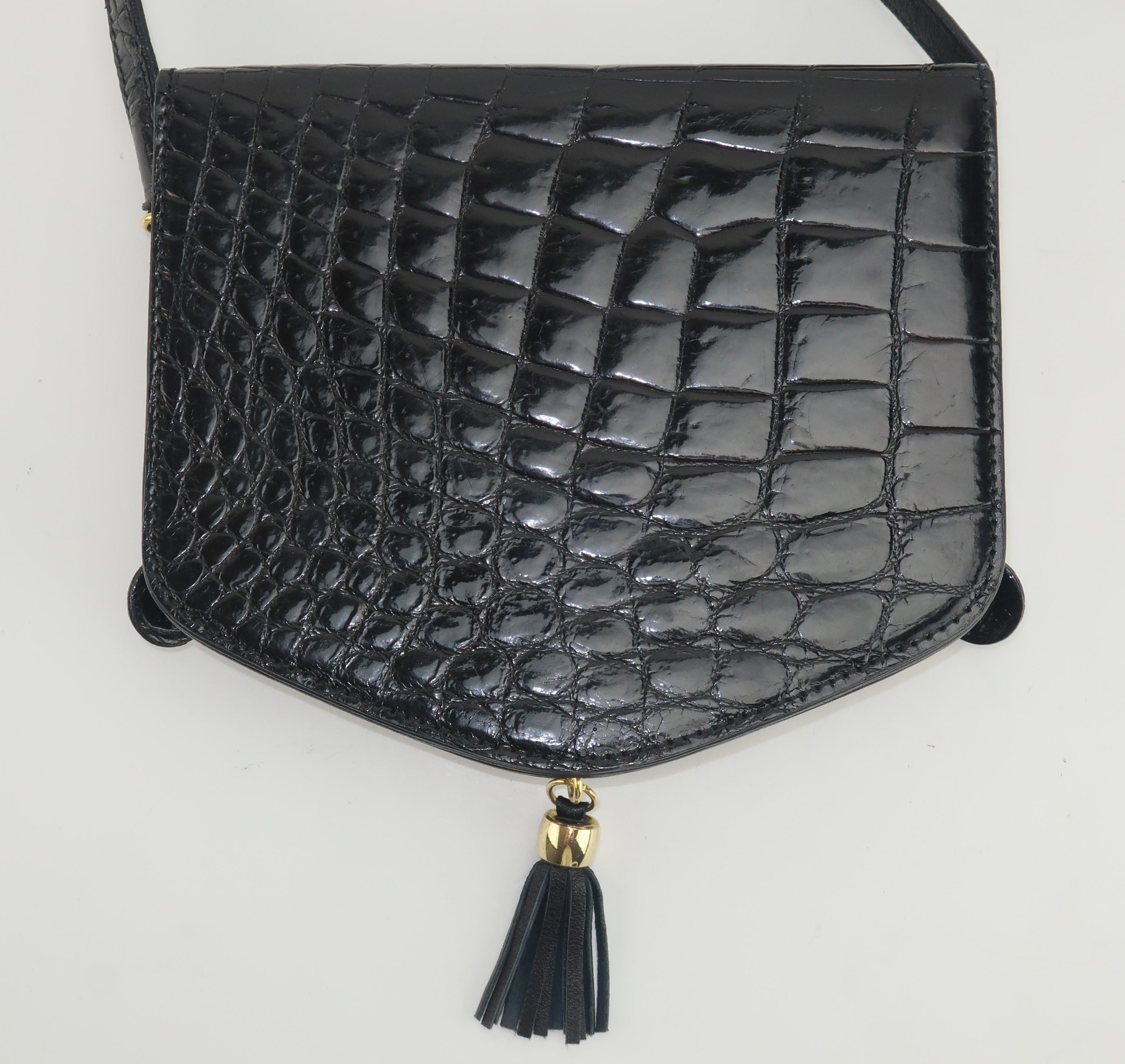 This Harrods black alligator embossed leather handbag offers a great combination of classic style and a chic look.  The body of the bag has a snap front flap closure with an extra long shoulder strap appropriate for cross body wear.  Gold tone metal