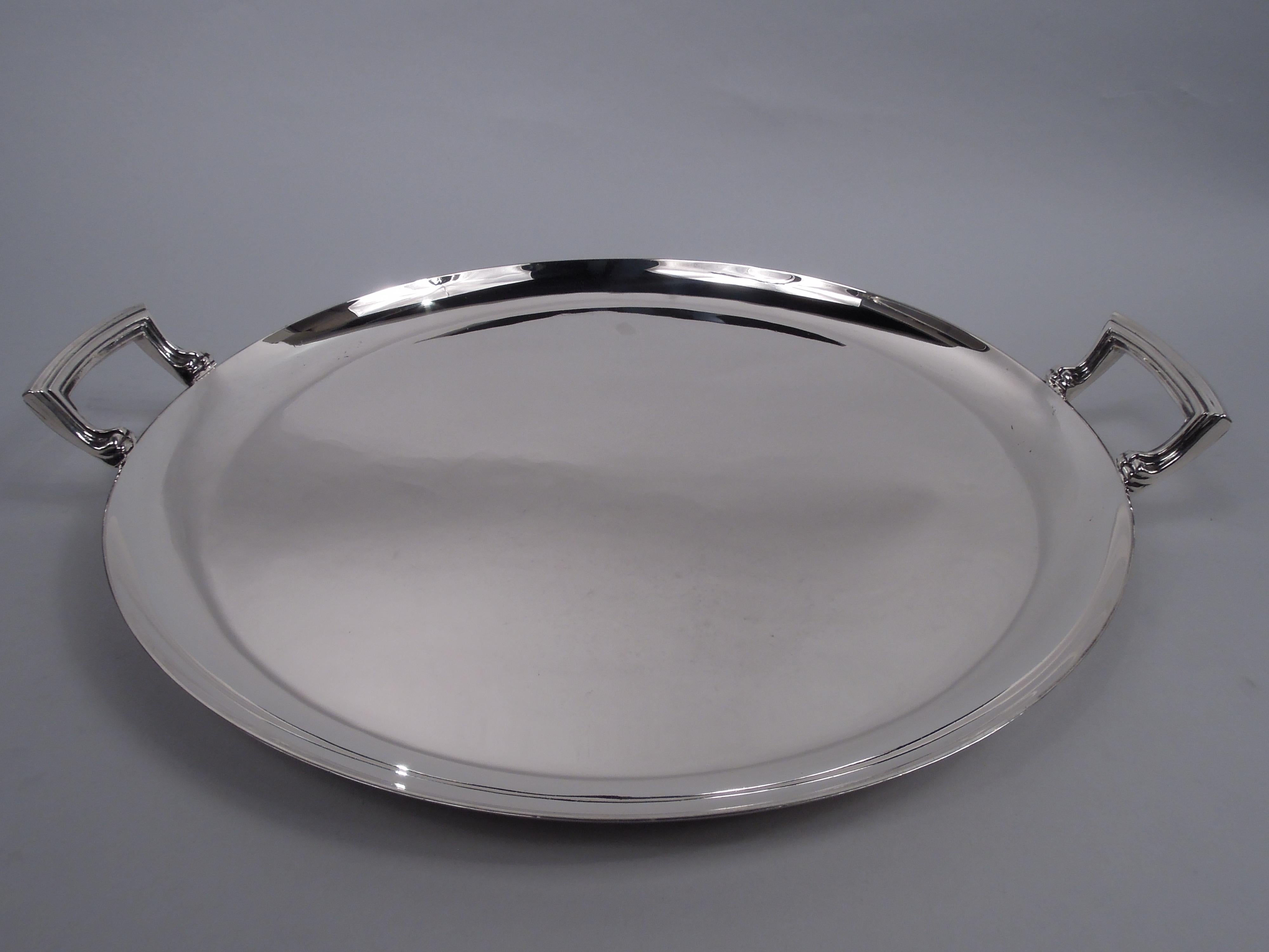English Art Deco sterling silver serving tray, 1938. Retailed by Harrods in London. Round with curved and tapering sides. Reeded bracket handles mounted vertically to sides. Capacious with nice balance and heft. Fully marked including retailer’s