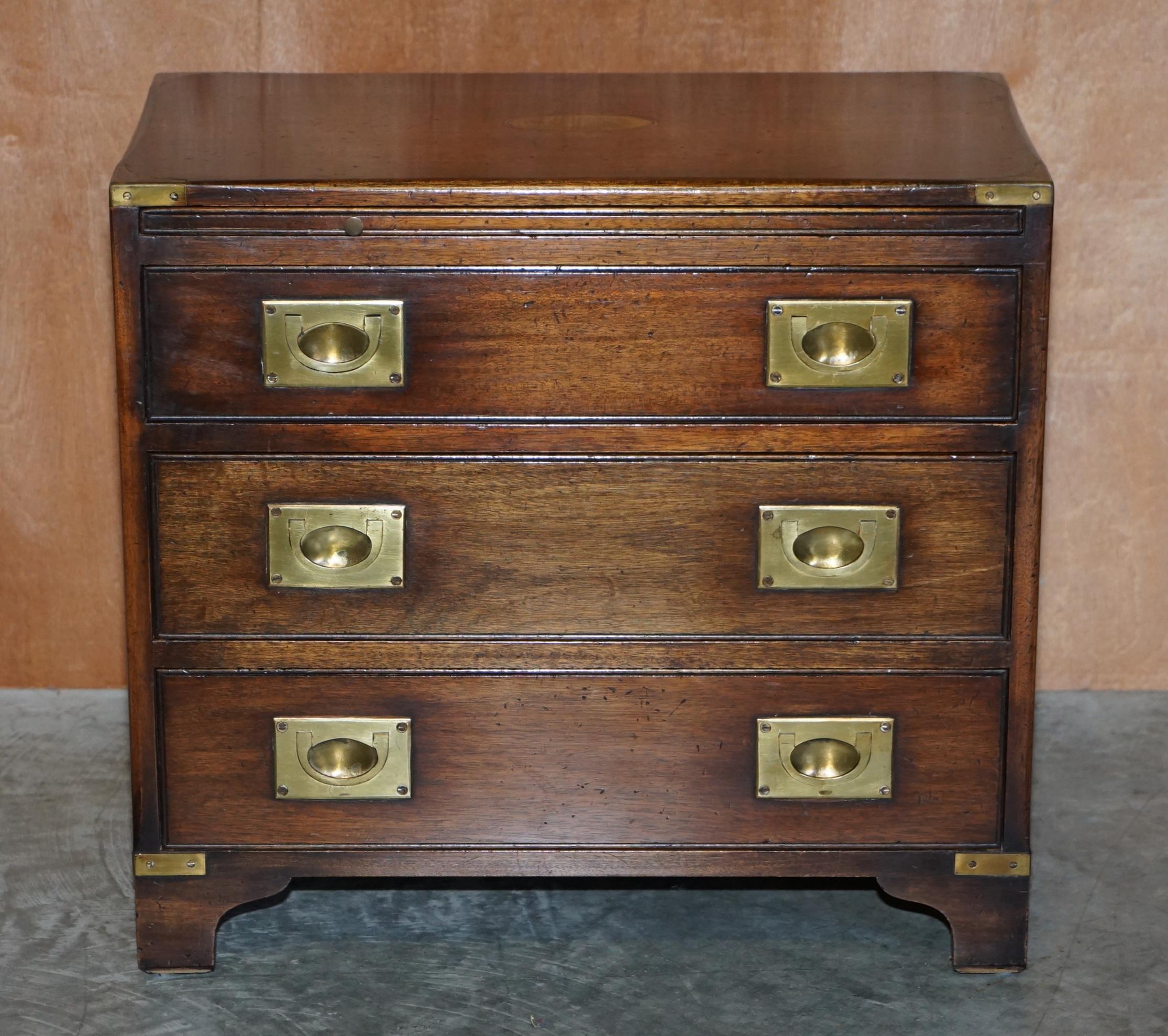We are delighted to offer this lovely Harrods Kennedy Military Campaign bedside table sized Bachelors chest of drawers with slip serving tray

This piece was made by R.E.H Kennedy and retailed through Harrods London, its solid mahogany and comes