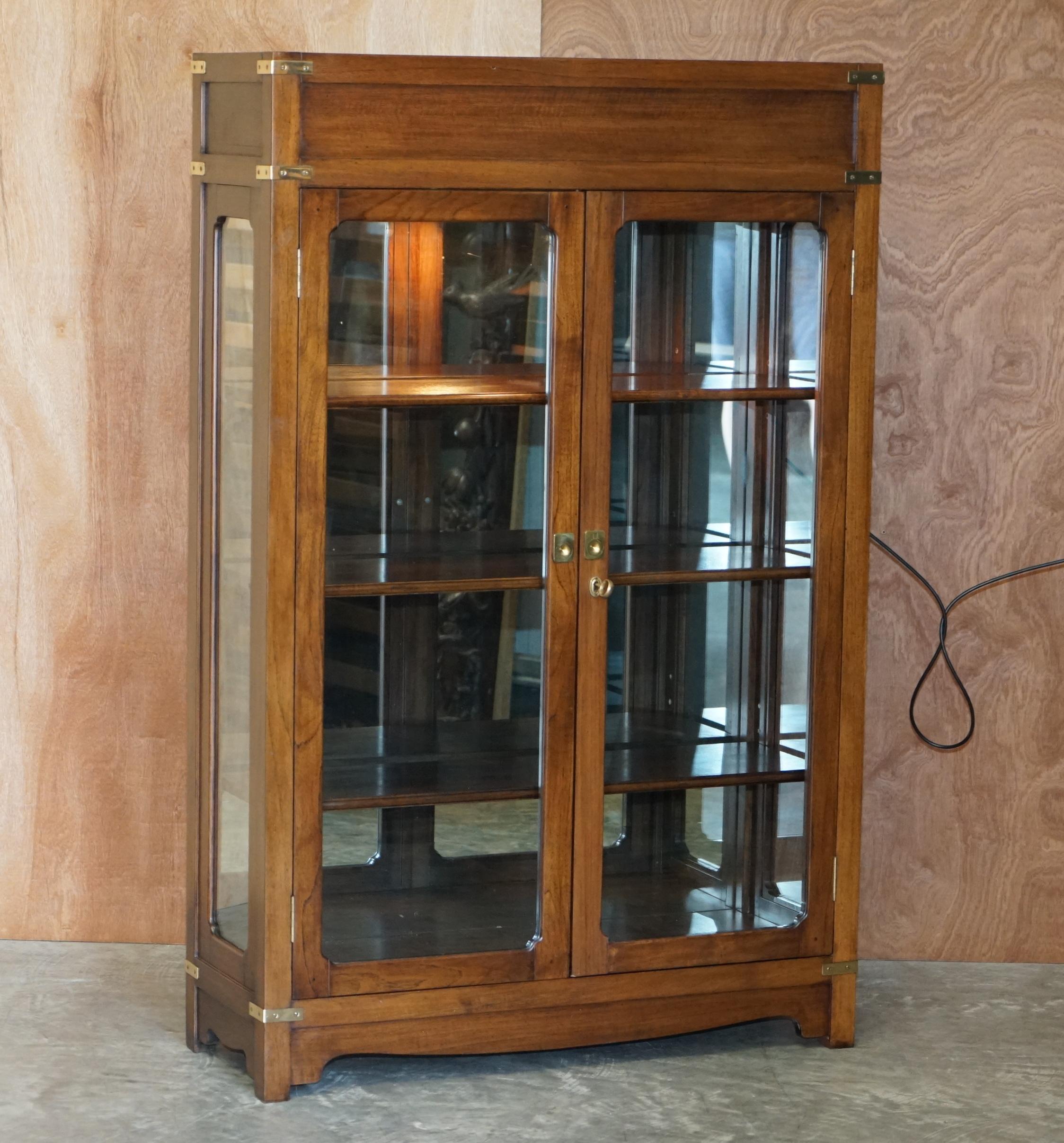 We are delighted to offer for sale this absolutely stunning Kennedy Furniture Military Campaign glass doored with mirror back and top light, display cabinet retailed through Harrods London 

A very well made and utilitarian piece of furniture. It