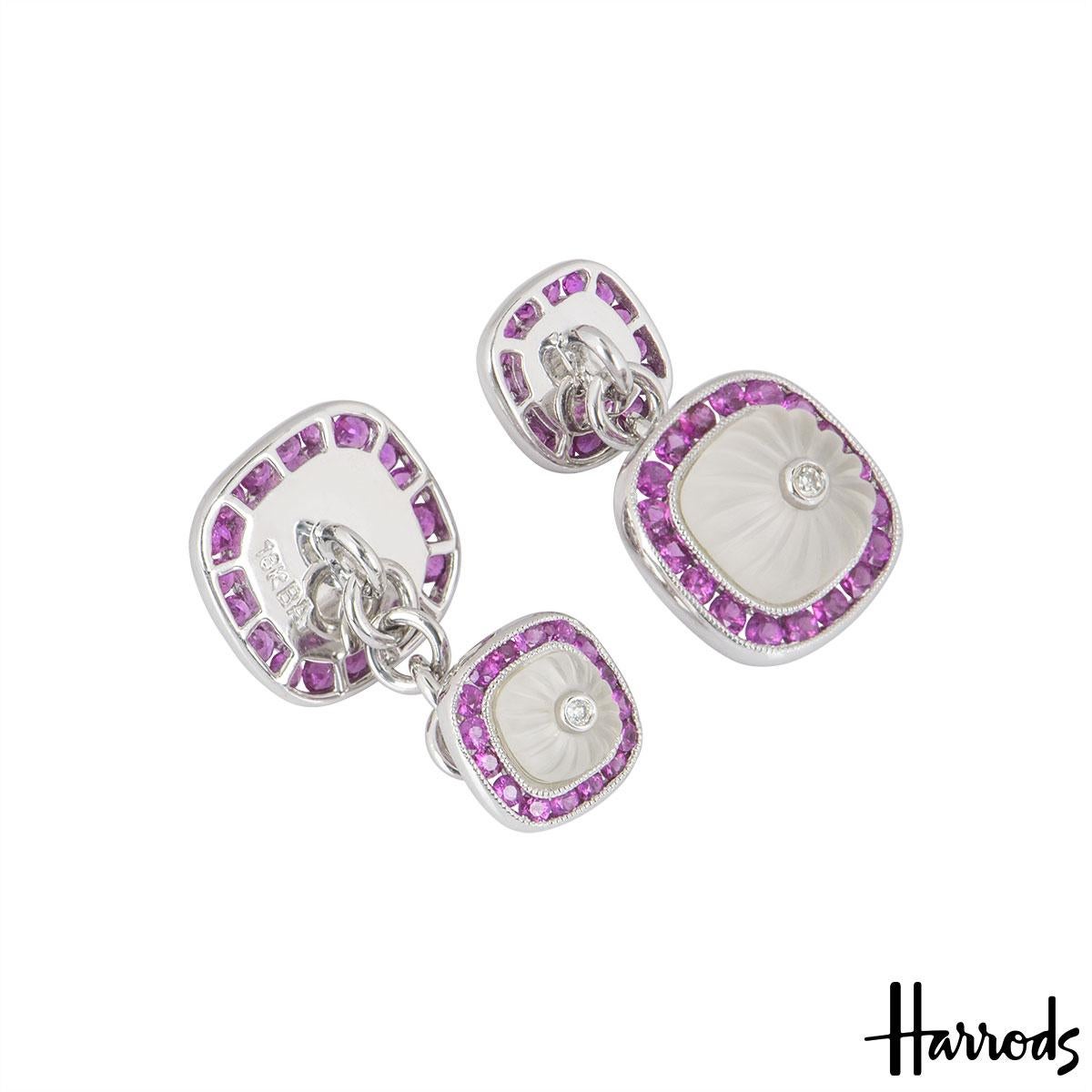 An 18k white gold pair of diamond and multi-gem cufflinks. The cufflinks are composed of 2 carved crystal stones alternating in size set with a round brilliant cut diamond in the centre surrounded by round rubies in a pave setting. The cufflinks are