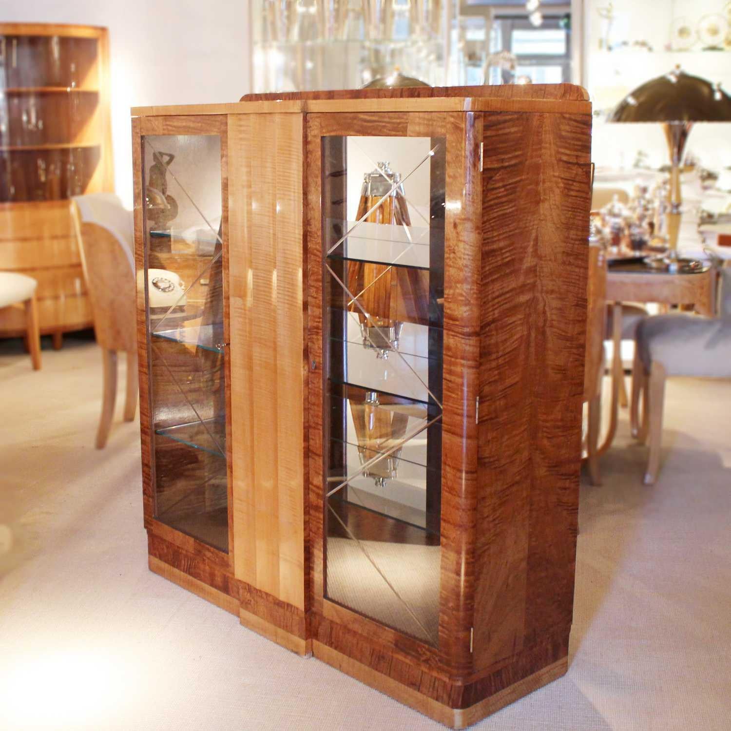An Art Deco display cabinet in satin birch, with fluted walnut central section and two glass fronted side cabinets.



  