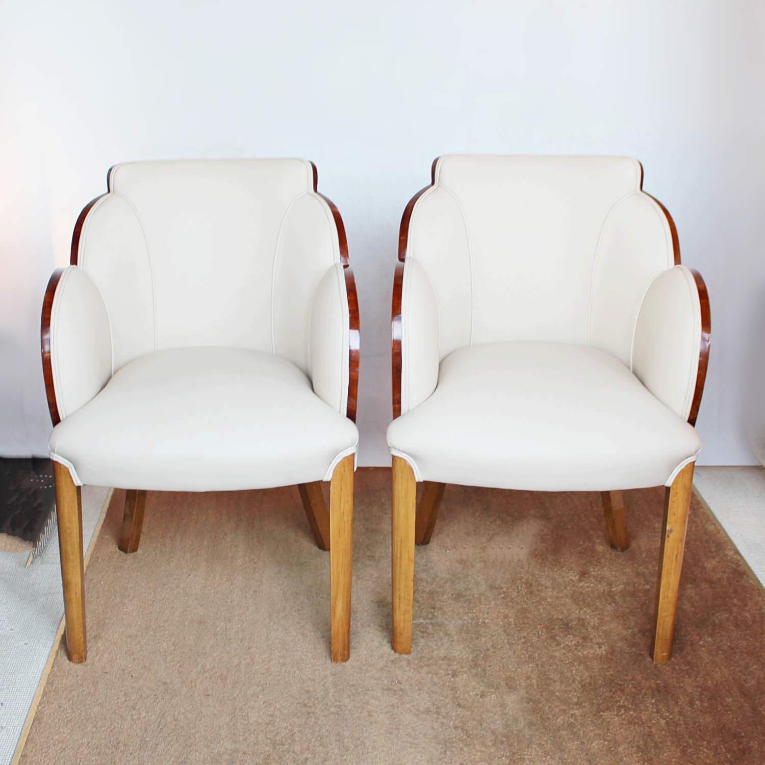 A pair of walnut wrapped, cloud back chairs. Burr walnut veneers, with straight grain walnut banding, upholstered in cream leather. 



