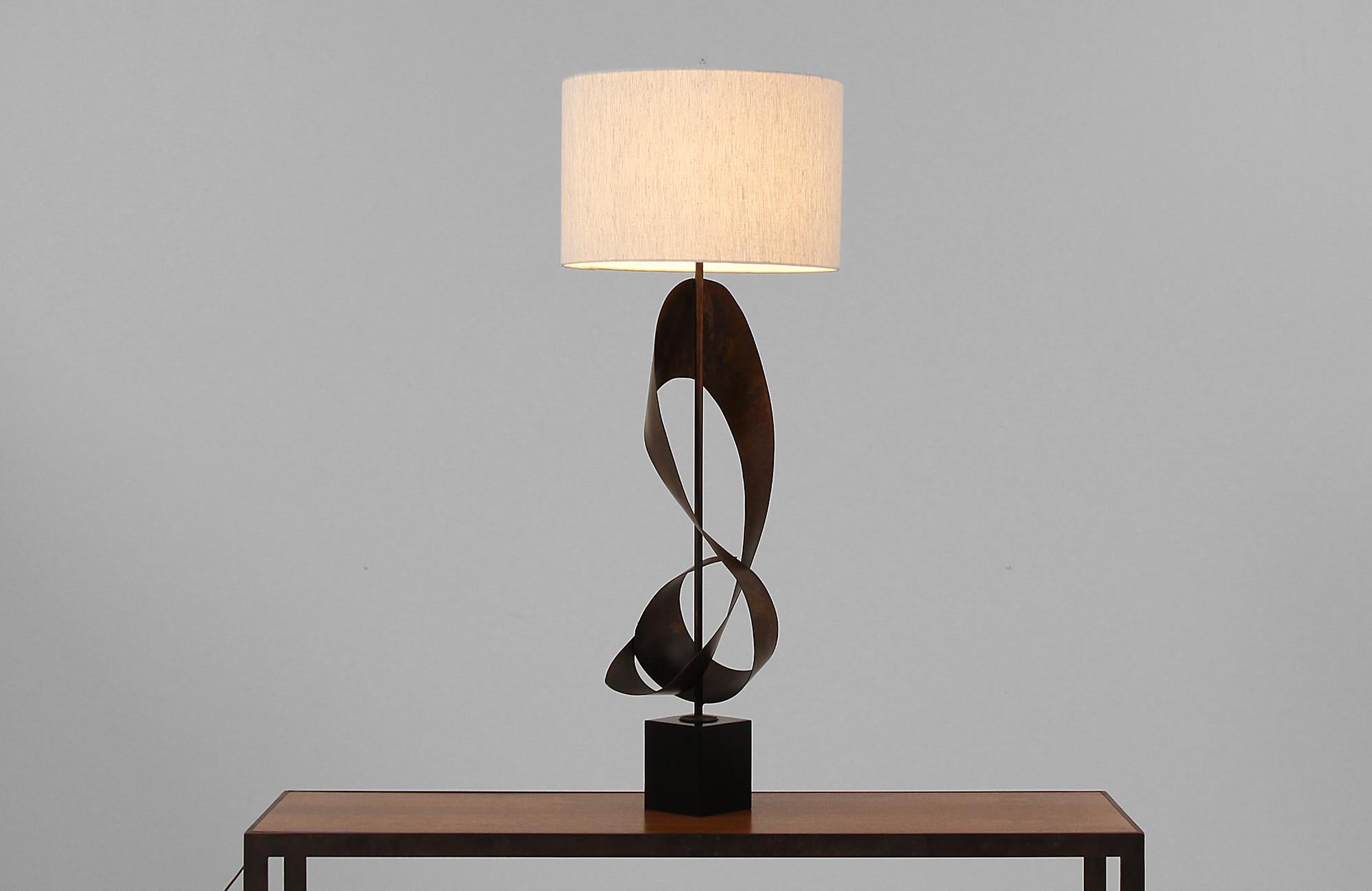 Brutalist ribbon-shaped table lamp designed in the United States by artist Harry Balmer for Laurel Lamp Co. circa 1960s. This stunning lamp features a modern abstract ribbon styled patinated steel body that sits on a black metal base for stability.