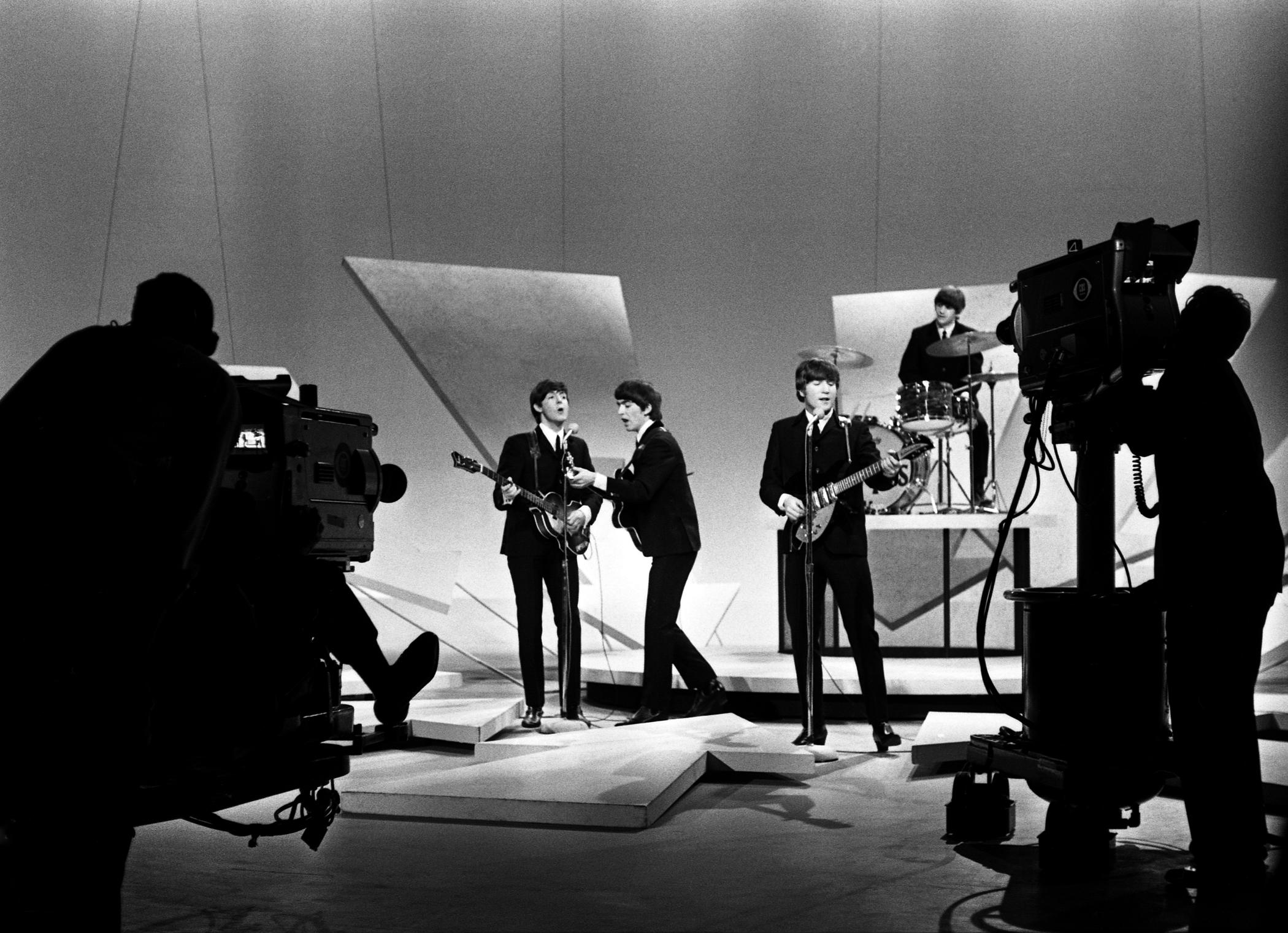 *Avec les caméras de production qui filment

Harry Benson est né près de Glasgow, en Écosse. Le photographe a été désigné pour voyager avec les Beatles lors de leur première tournée aux États-Unis en 1964. Sa photo emblématique montre le groupe en