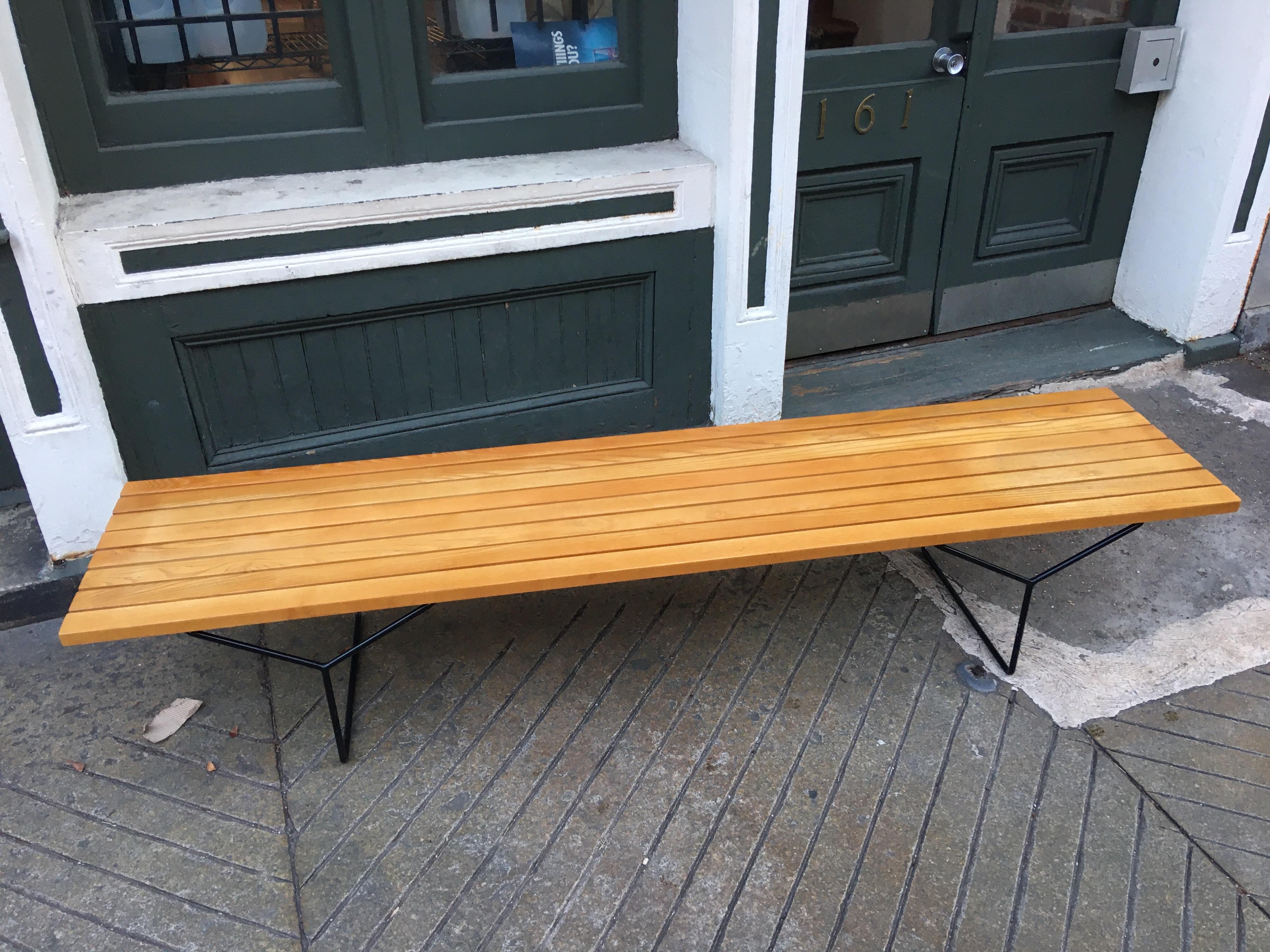 Bertoia bench for Knoll. Longest version of the sizes offered. Solid oak slats with black iron legs. Retains original label. New finish. Measures: 82
