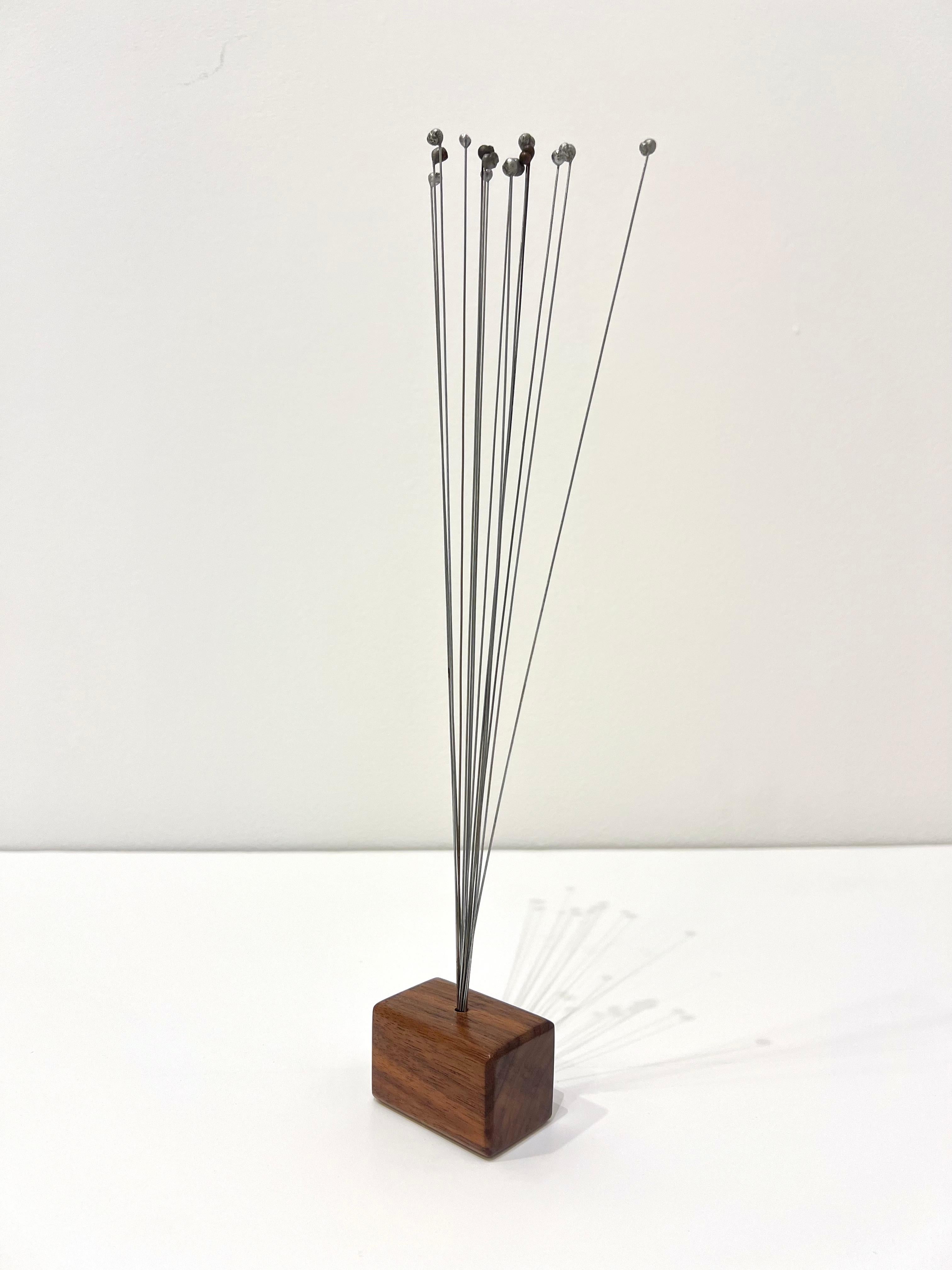 One of a kind abstract sculpture composed of metal needles from Harry Bertoia's iconic Dandelion Sculpture, circa 1960s.
Minimalist walnut base added later.