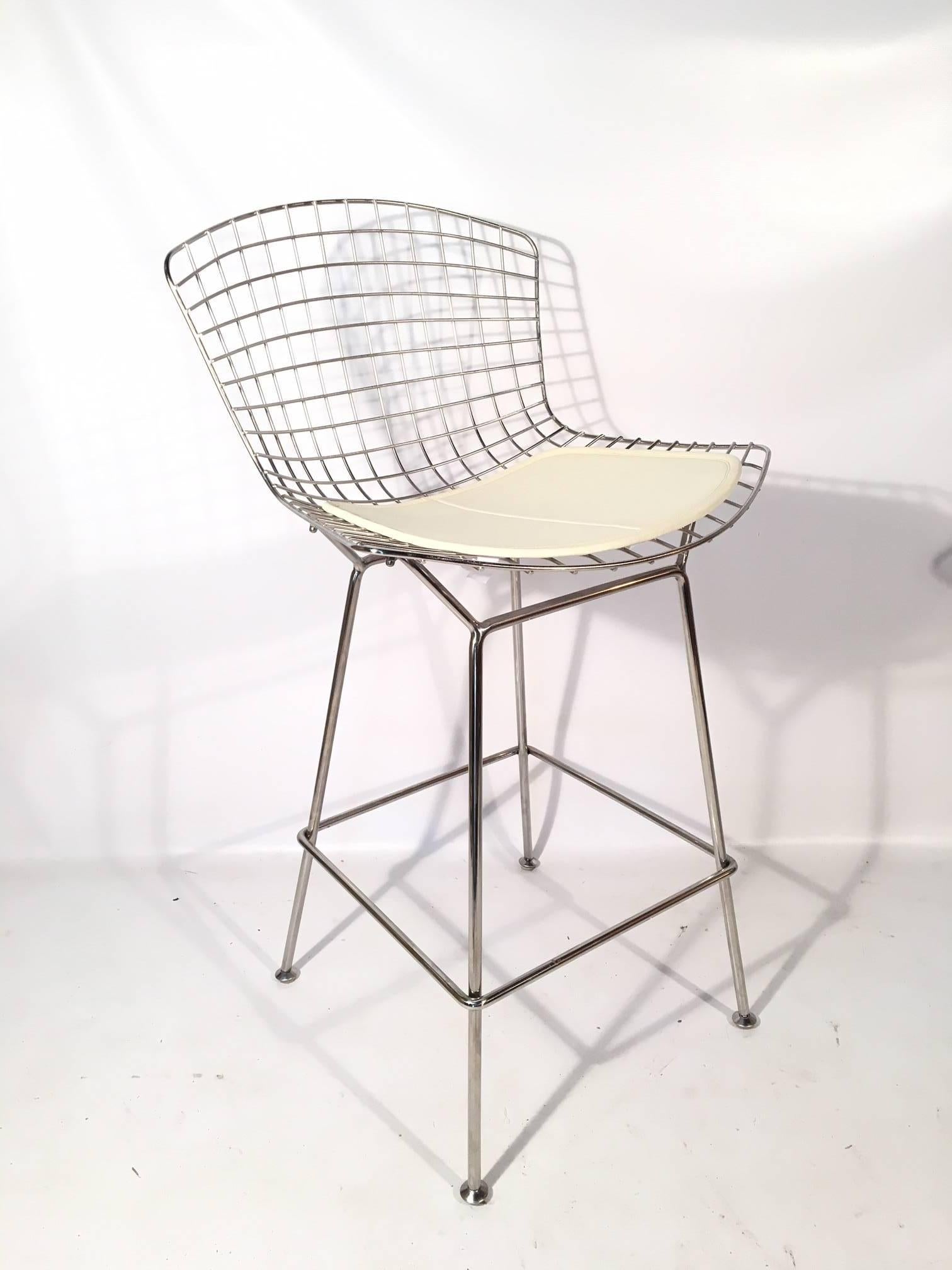 Set of five iconic chrome wire bar stools designed by Harry Bertoia for Knoll. This set is unmarked by Knoll, which means they are pre-2004 production. Near mint condition.  In addition to the white seat pads, this set includes a set of pink back