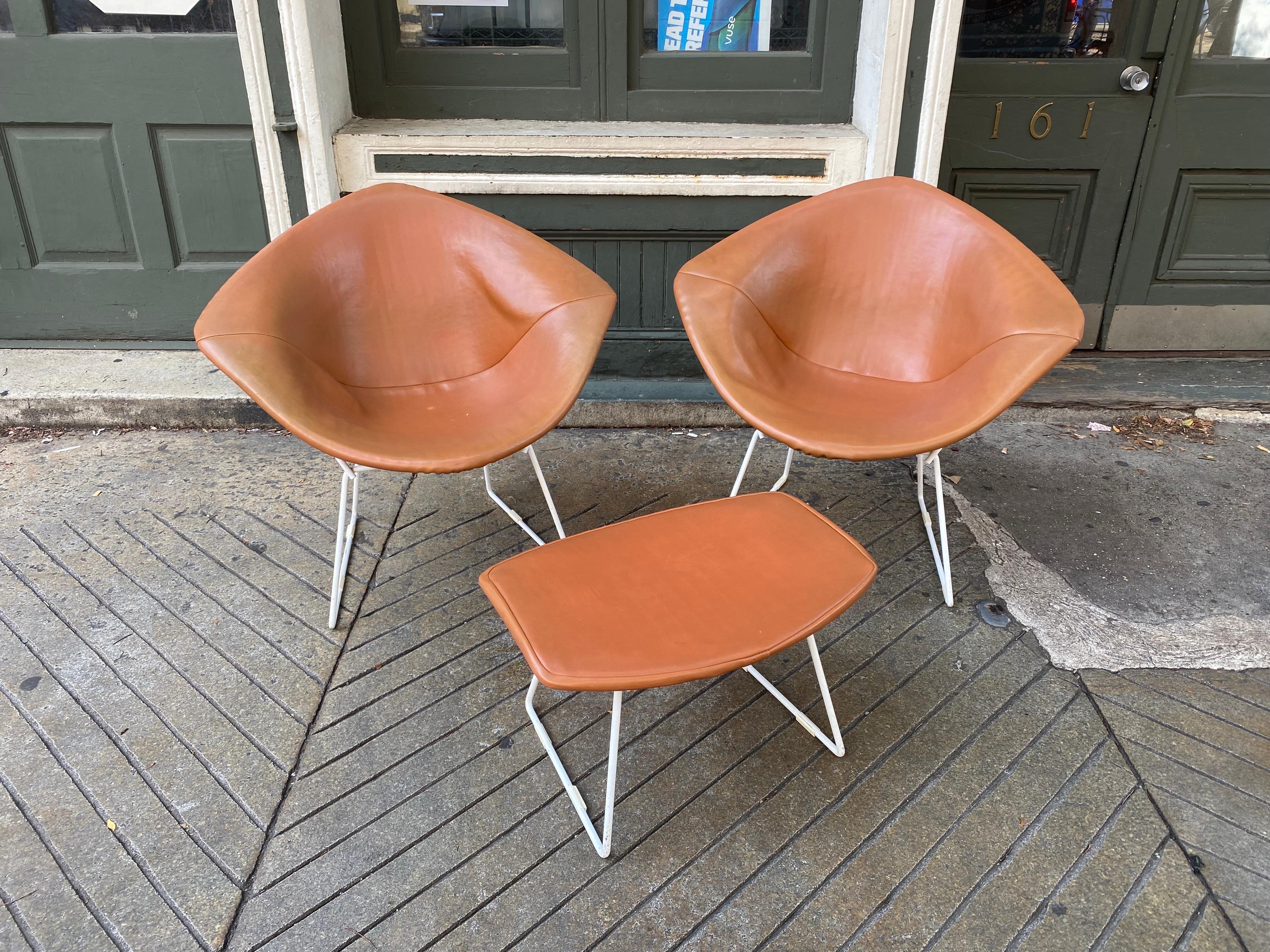 Harry Bertoia for Knoll pair of small diamond chairs with matching ottoman.  Set probably dates to the mid 1970's.  Vinyl seats with cloth backing that you see through the cage of chairs from behind.  There is one light spot on vinyl as seen in