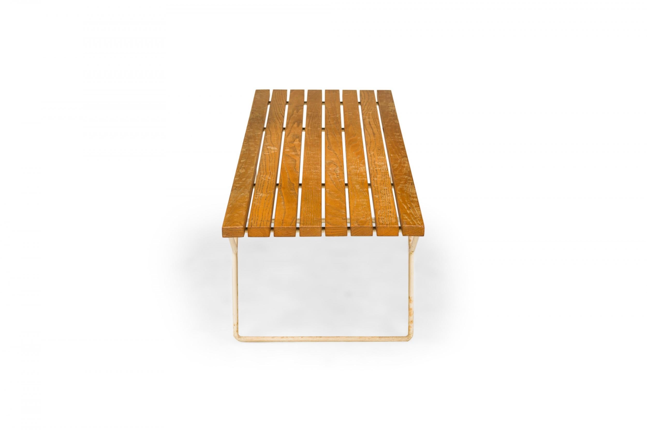 American Mid-Century rectangular bench with a wooden slat seat resting on two white finished Y-shaped metal legs. (HARRY BERTOIA FOR KNOLL INTERNATIONAL)

Some chipping to finish on the legs.