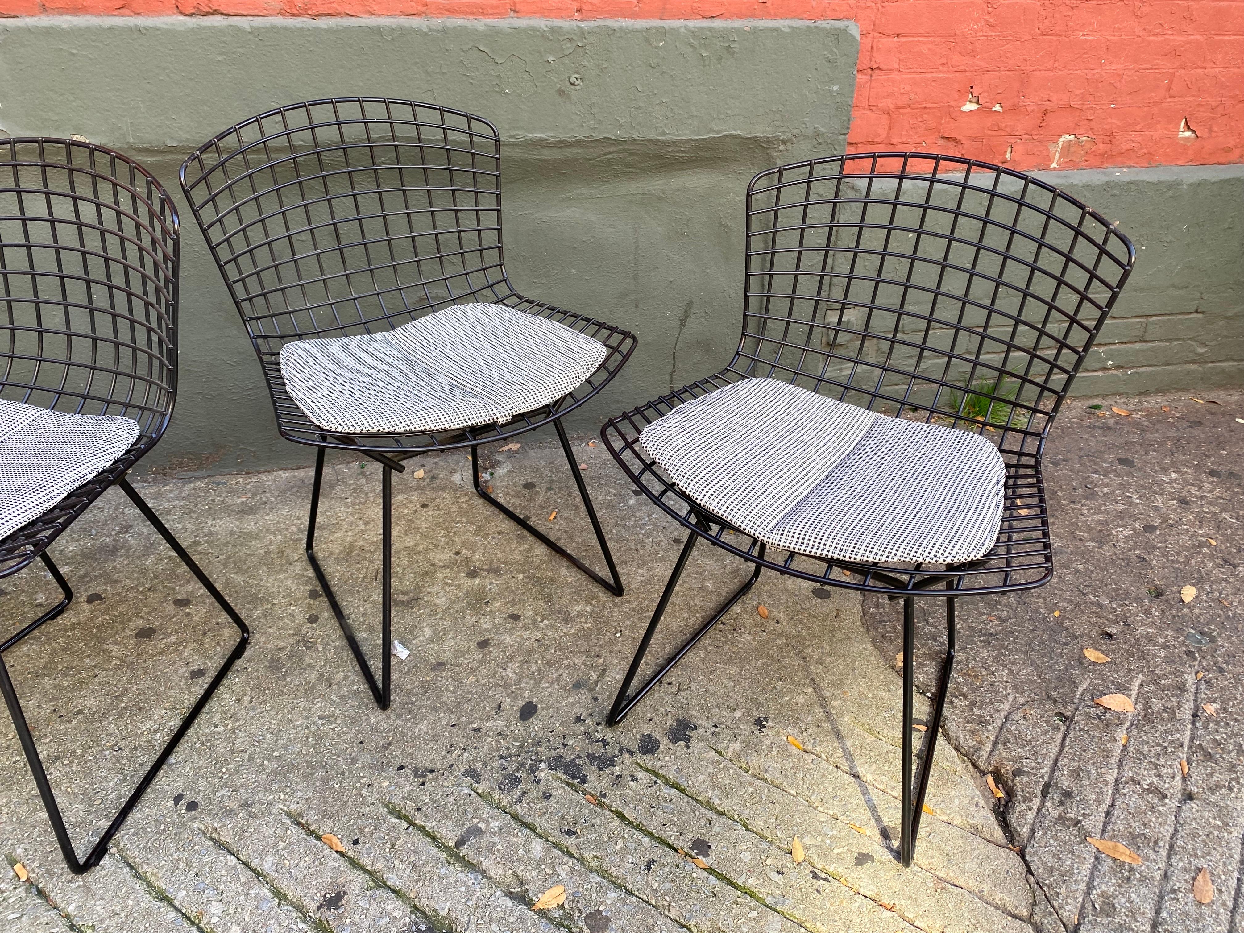 Set of 4 Harry Bertoia side chairs for Knoll. Nice solid chairs that have had newer covers made in the last 5 years or so. There are 2 weld repairs to bases, one seen in photo. Very solid and not really visible unless really looking! Chairs retain