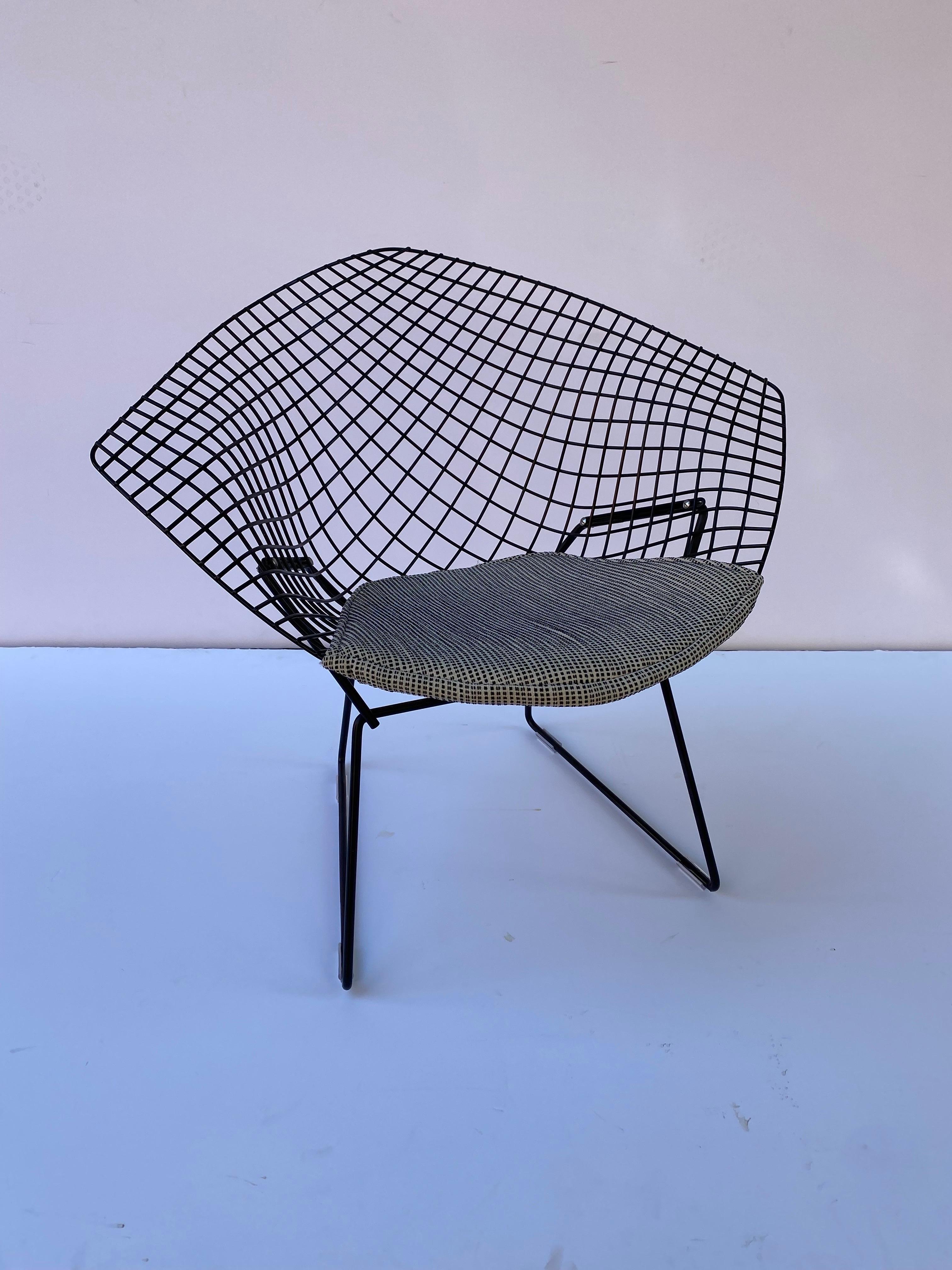 Harry Bertoia pair of small diamond chairs. Black Frames with newly upholstered seat pads. One chair has new plastic glides and one has older glides. Black Frames are in very nice shape! Metal across floor area has been repainted, but blends