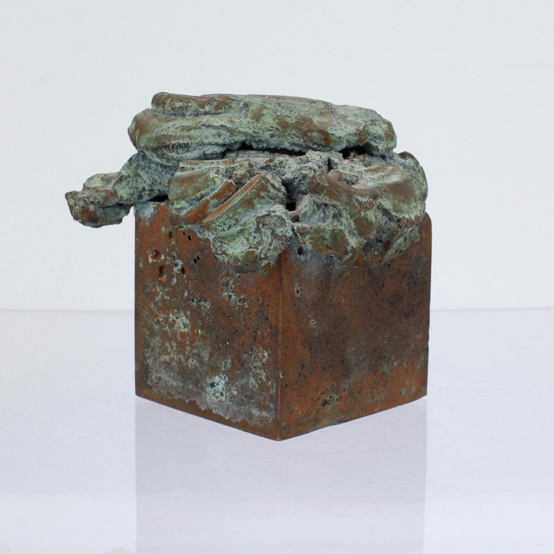 An original 'melt pressed' bronze sculpture by Harry Bertoia.

With a cube shaped base, pressed top, and verdigris patina throughout.

These rare, small-scale, experimental works were often done by Bertoia after hours in his shop.

This bronze