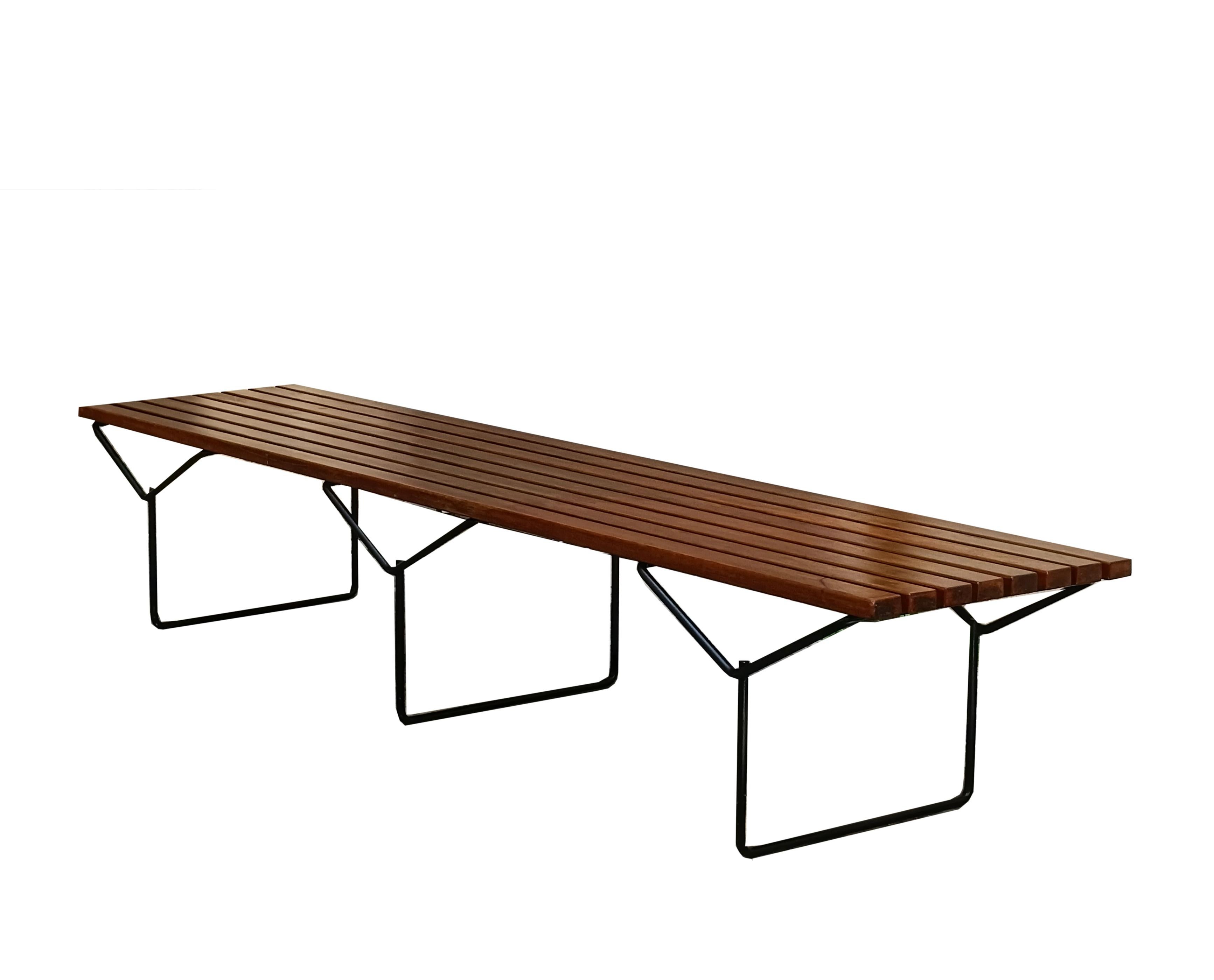 Banc ou table basse iconique et splendide avec des lattes en bois de teck et une structure en métal noir. Le banc a été conçu par Harry Bertoia pour Knoll. Il présente la patine du temps.