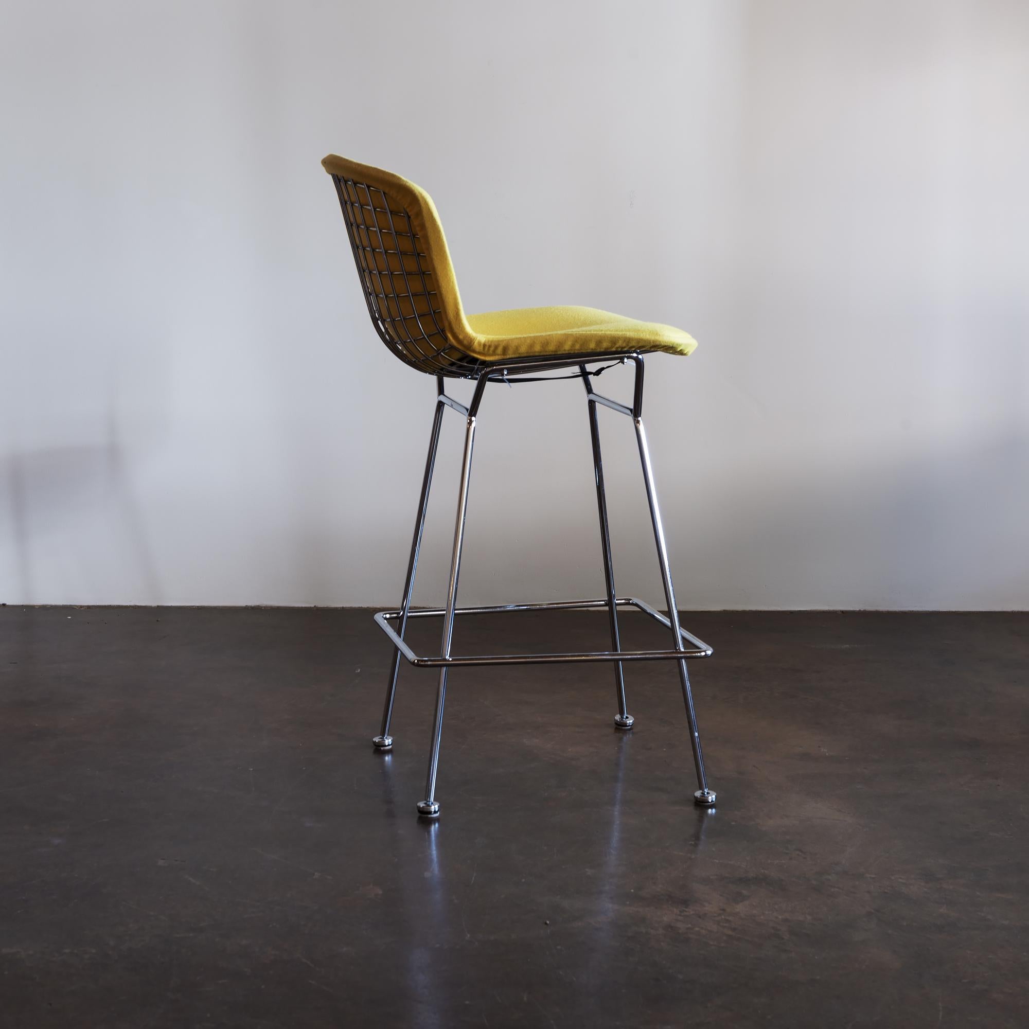 Iconic set of four bar stools by Harry Bertoia for Knoll International. Chrome frames with black leather seat pads. Set comes with original yellow covers. United States, 1970s.