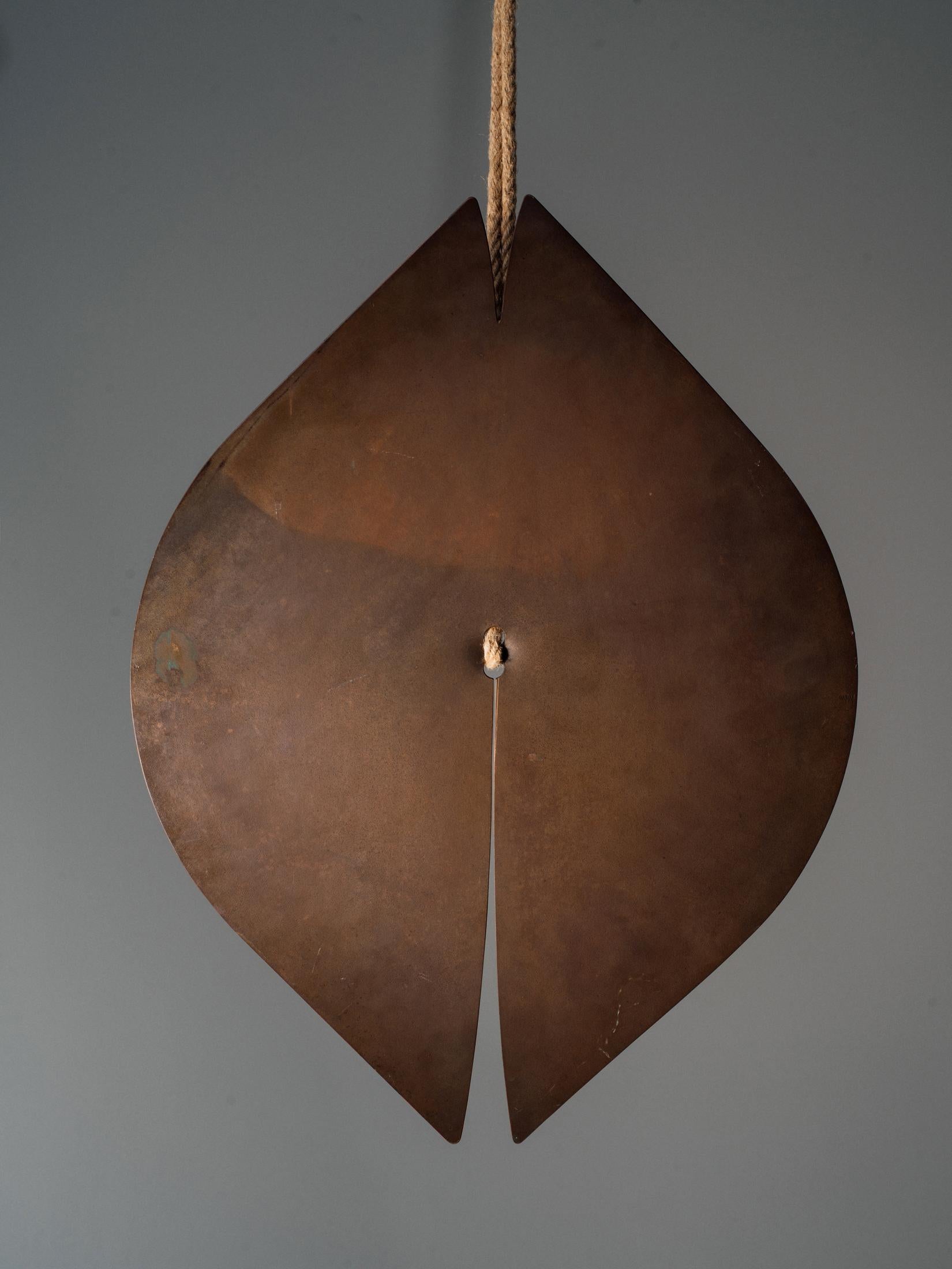 A sublime, single slab gong in cut, hammered and drilled brass by Harry Bertoia with slits at either end, suspended by jute cord. Beautiful scale with surface exhibiting original, untouched patina commensurate with age. Offered with certificate of