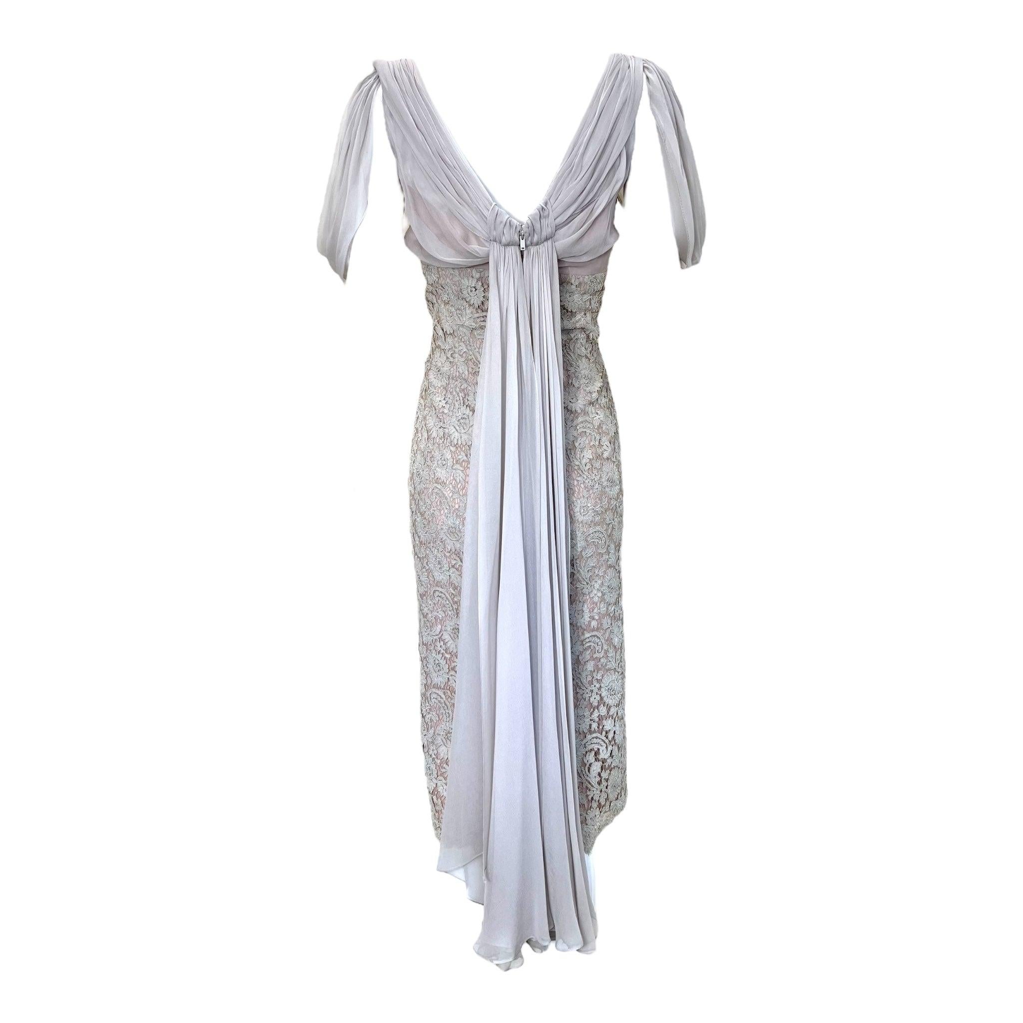 Sweet and feminine Harry Cooper dress circa 1960's. Fitted bodice dress with lace overlay beginning at under bust. Draped chiffon sleeves gather at the back to drop into a waterfall mini-train. Classic sheath silhouette hits at mid-calf length. The