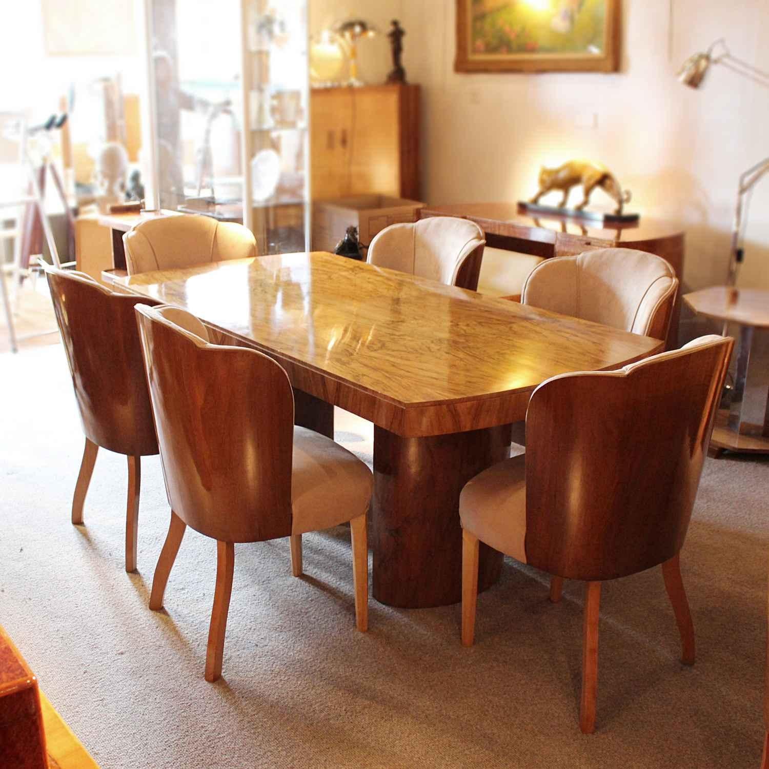 An Art Deco dining table with six chairs by Harry & Lou Epstein. Figured walnut table set over pedestal legs. Chairs wrapped in walnut and upholstered in oatmeal Alcantara suede fabric.

Dimensions:

Table: H 78 cm, W 91 cm, L 184 cm

Chairs: