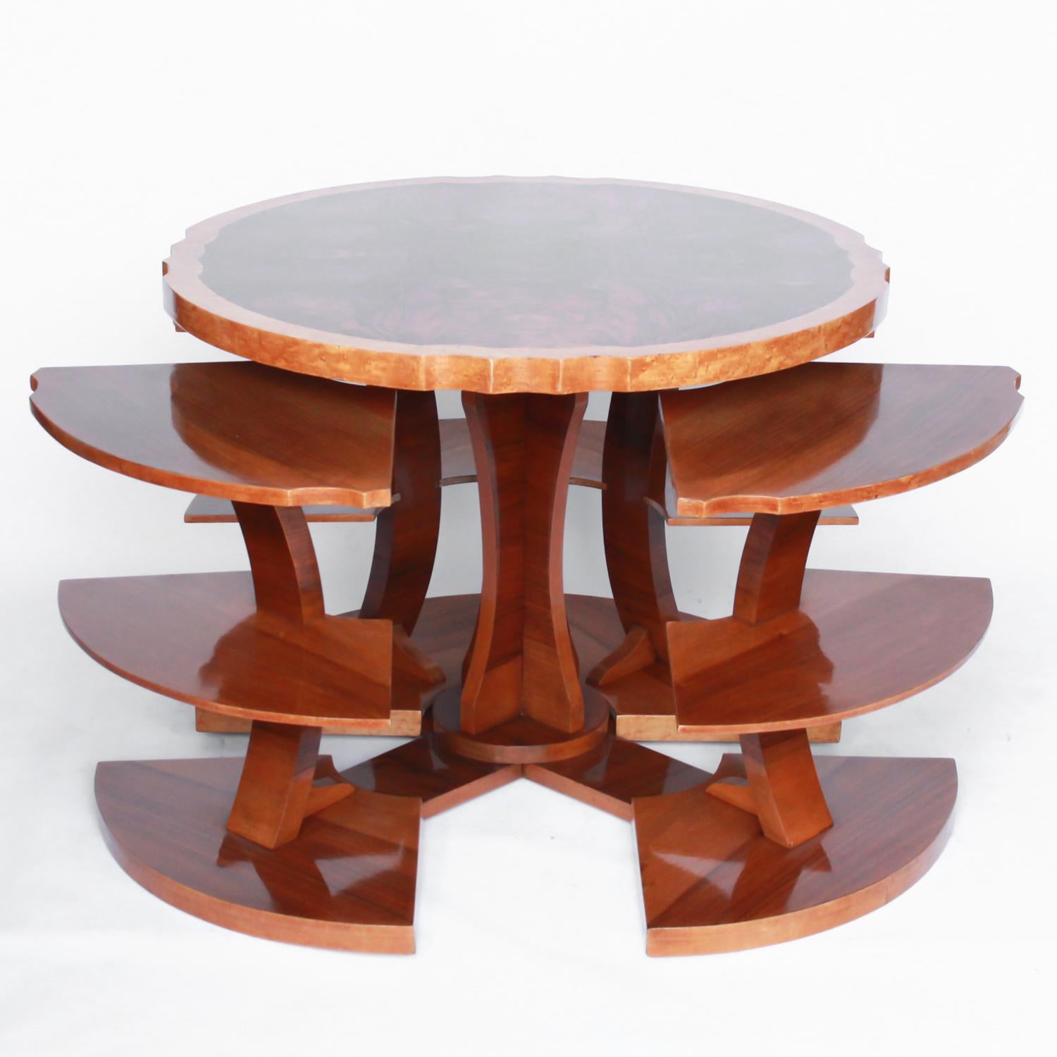 Art Deco, figured walnut veneer nest of tables. A shaped table with cross-footed base and four integral side tables. Burr and straight grain walnut throughout with bird's-eye maple border.

Dimensions: D 75cm H 57cm

Nest W 51cm Nest H 49cm D