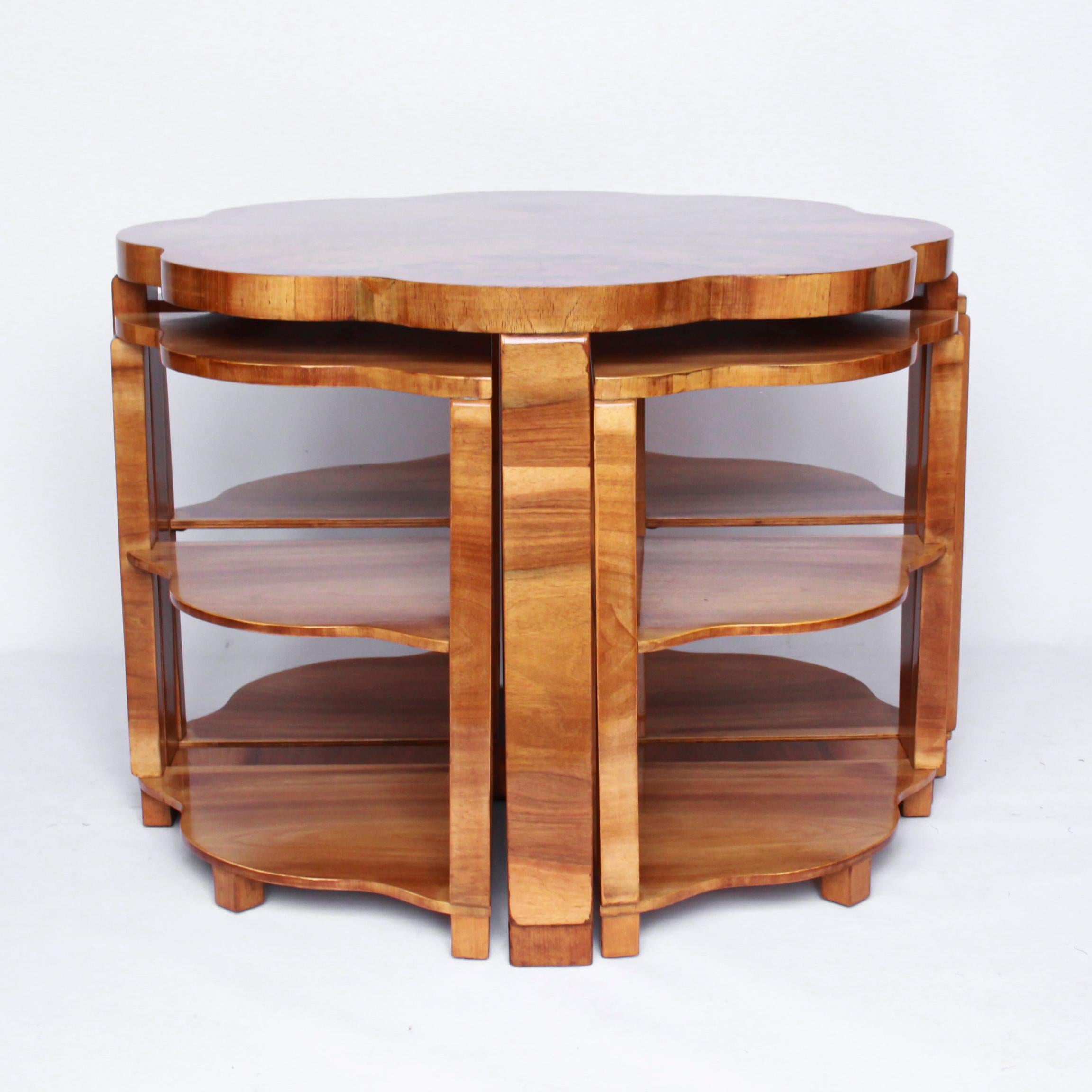 An Art Deco nest of tables by Harry & Lou Epstein. Burr walnut veneered, cloud shaped tabletop, with a straight grain walnut banding and straight grain walnut veneered legs. Four pull out / pull-out side table nests with matching cloud