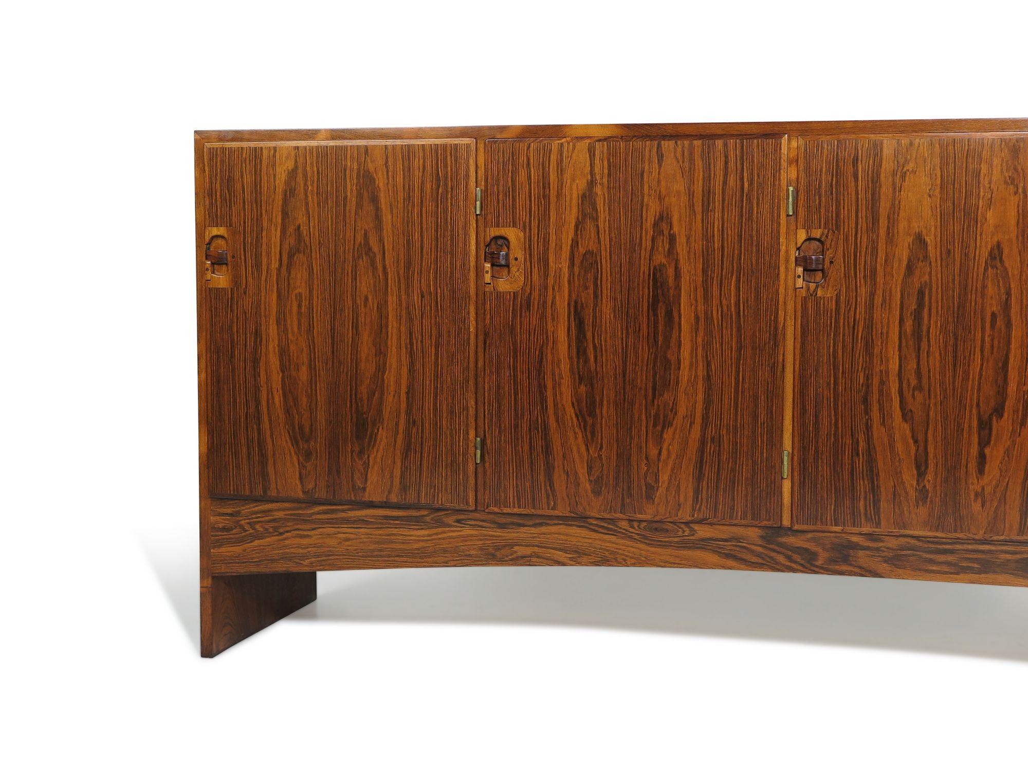 Large Mid-century Danish rosewood credenza designed by Harry Østergaard for Randers Møbelfabrik, 1960, Denmark. The cabinet is crafted of figured Brazilian rosewood with five book-matched doors featuring uniquely sculpted latch pulls with exposed